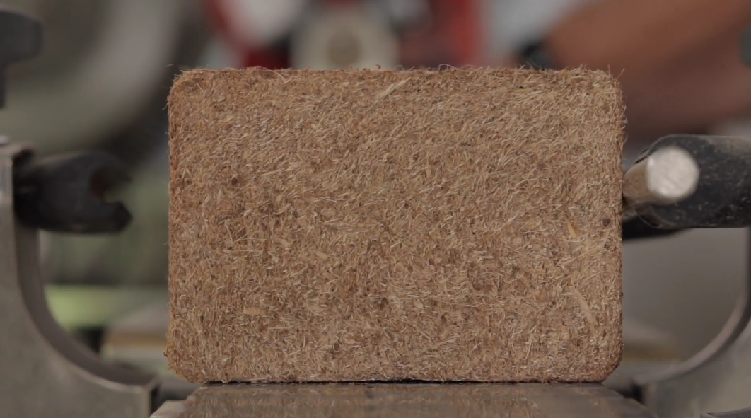 Close-up of a rectangular block of compressed sawdust or wood shavings.