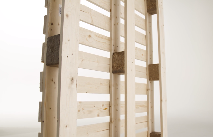 Wooden pallet with some concrete blocks attached between the planks.