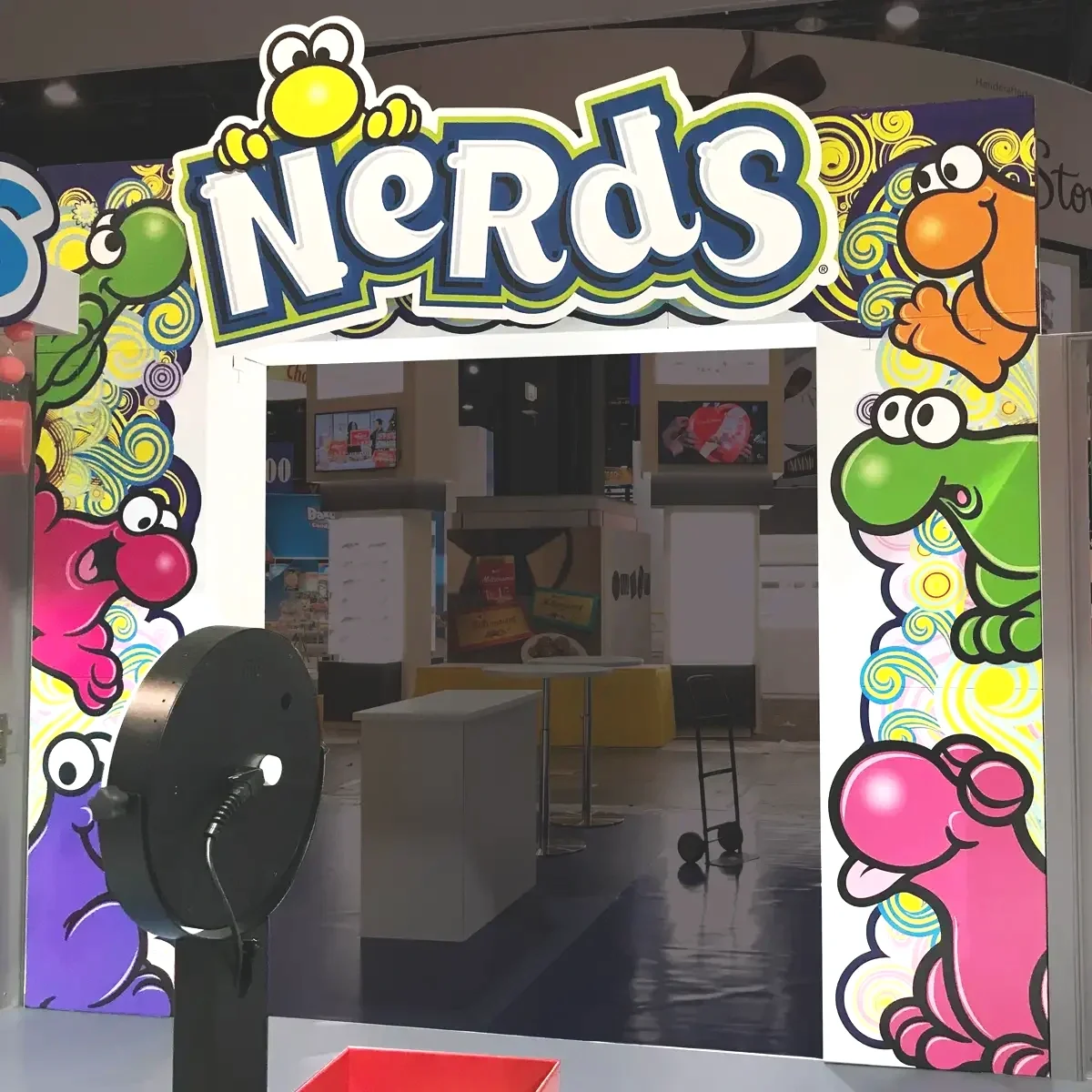 Colorful archway with cartoon characters of frogs and monsters and the word 'Nerds' at the top.