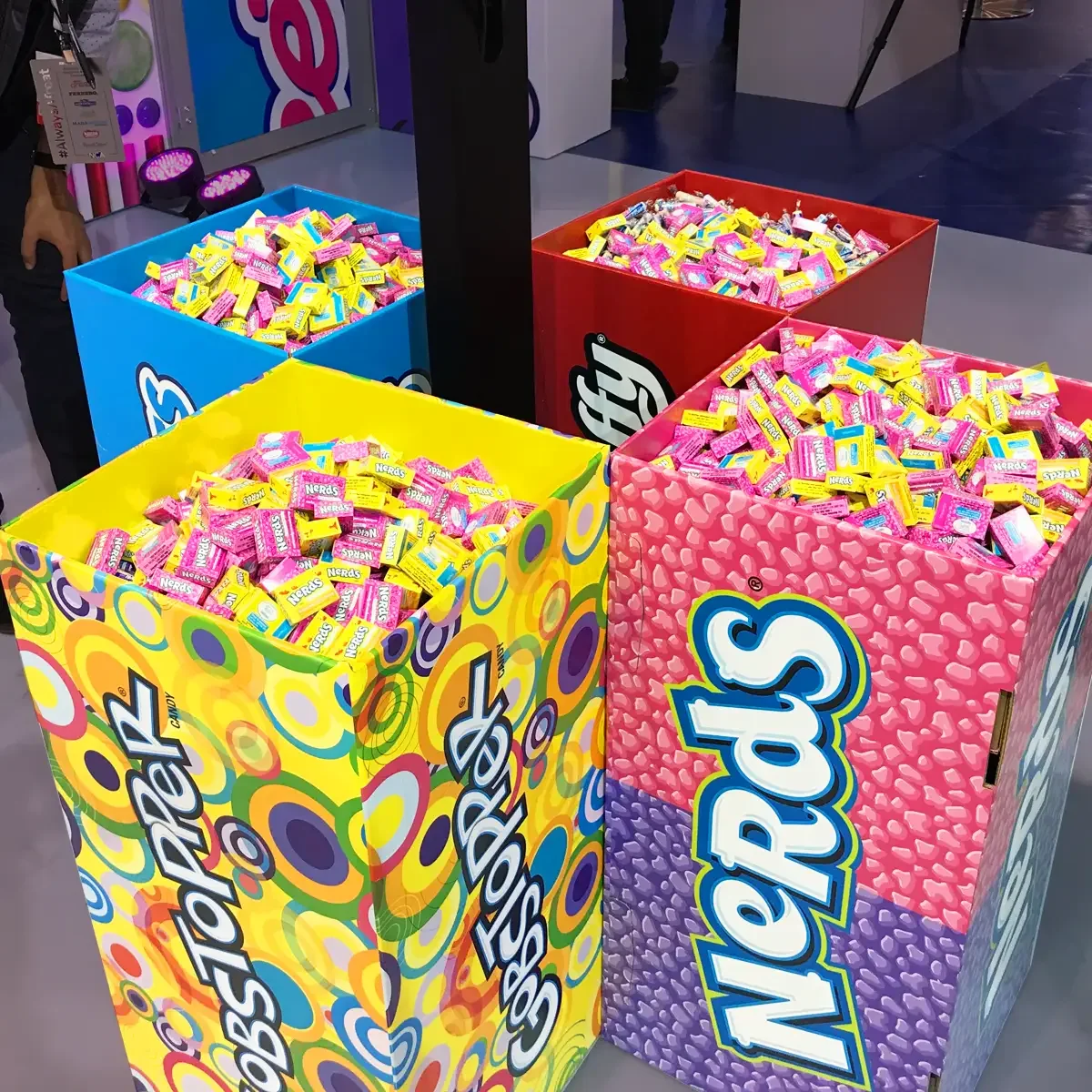 Large colorful display boxes filled with packs of Nerds candy in pink, yellow, and blue flavors.