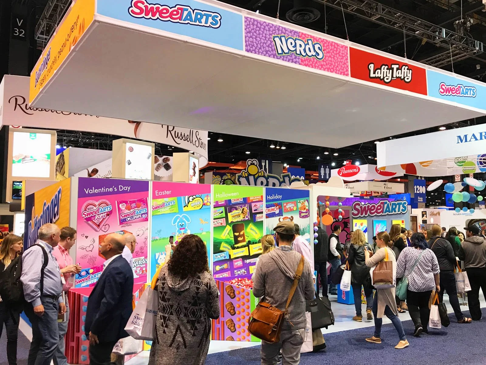 Trade show booth for SweetARTS and Nerds candy, with multiple display panels and visitors browsing.