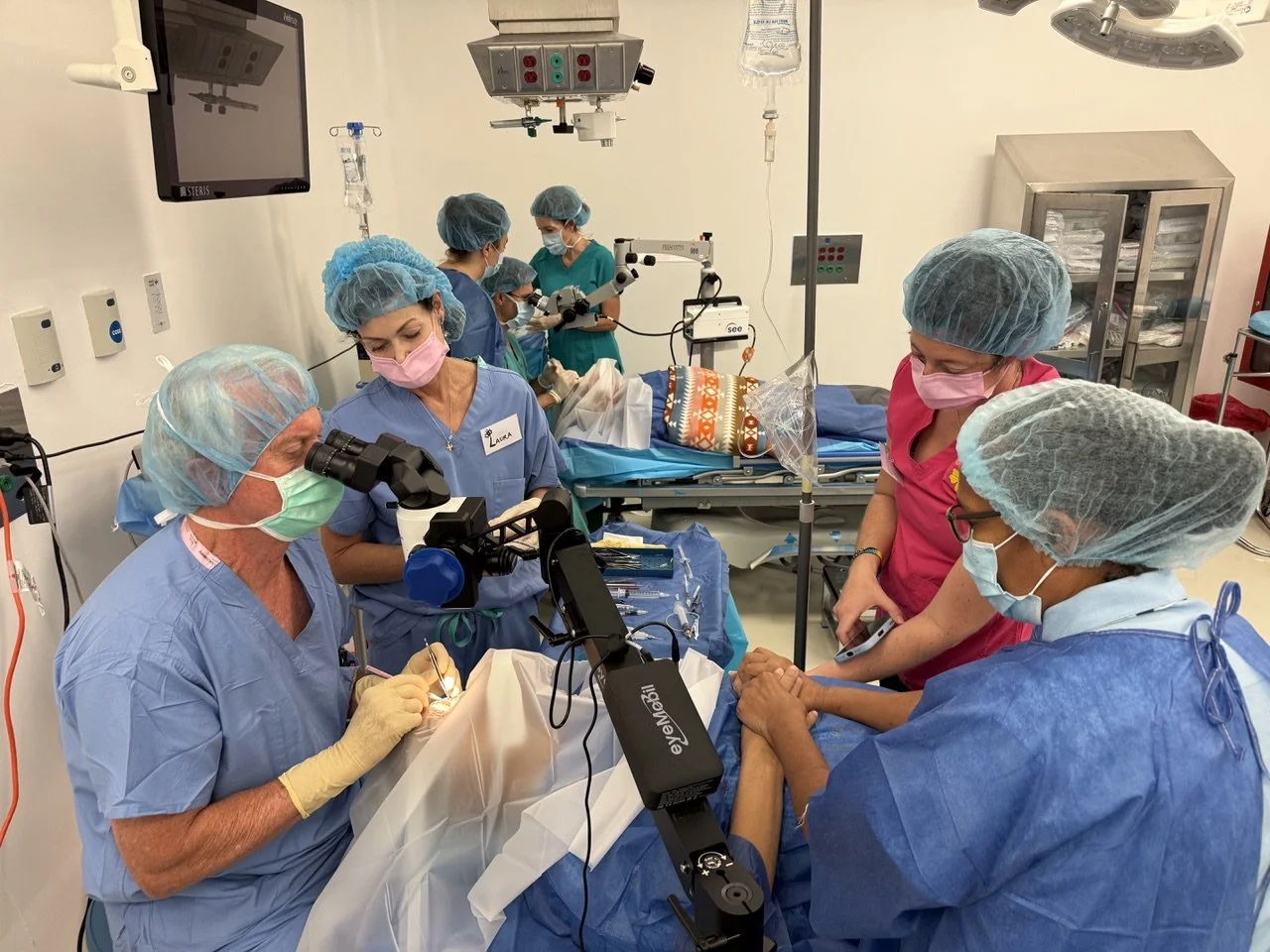Medical team performing a surgical operation in an operating room with surgeons, nurses, and medical equipment.
