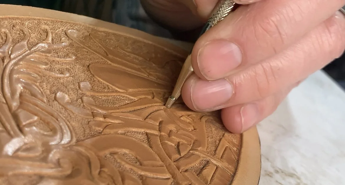 Close-up of a Traditional Norse Knotwork design being carved into a piece of leather with a beveling tool.