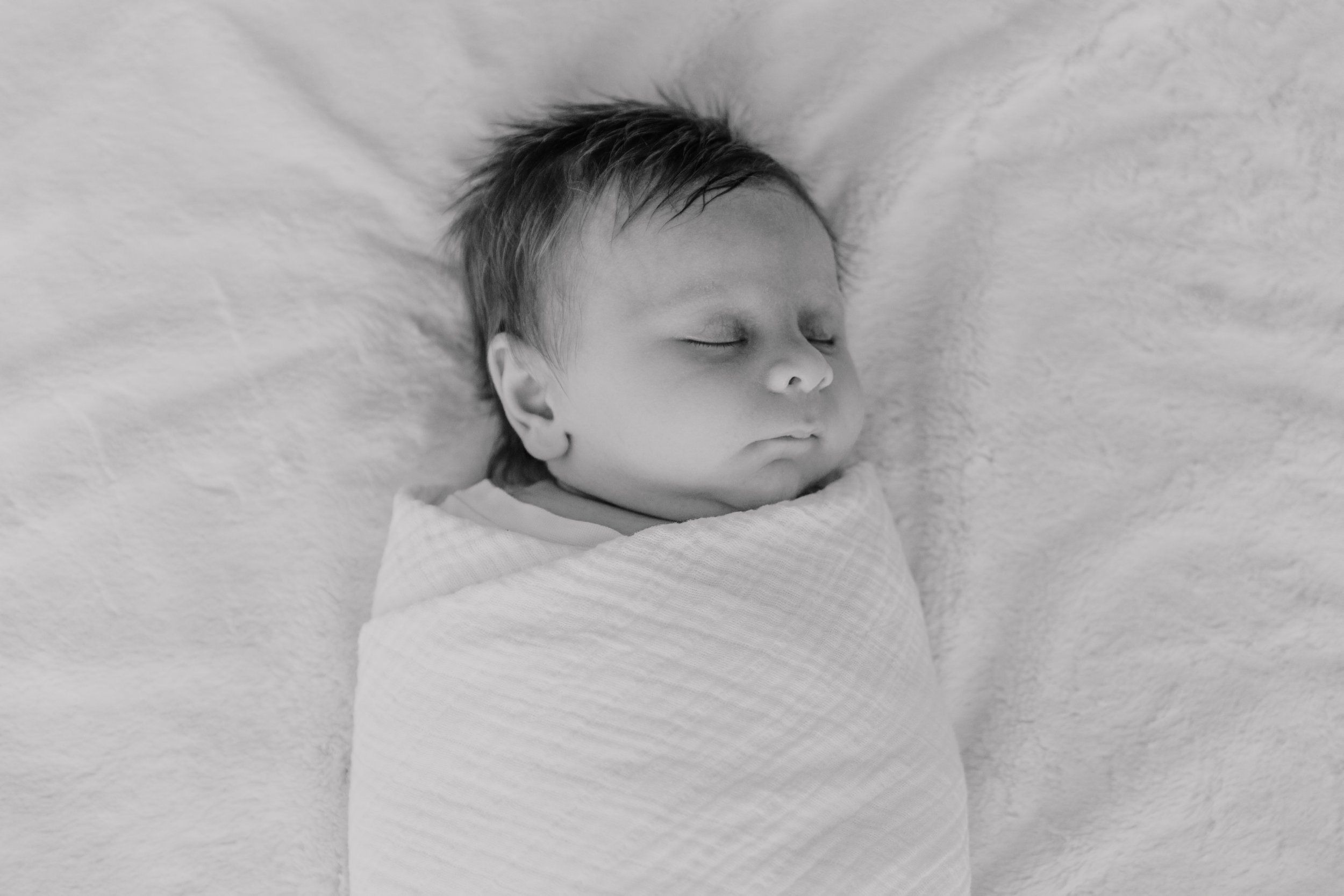 Newborn photography highlighting peaceful, candid moments of a newborn baby.