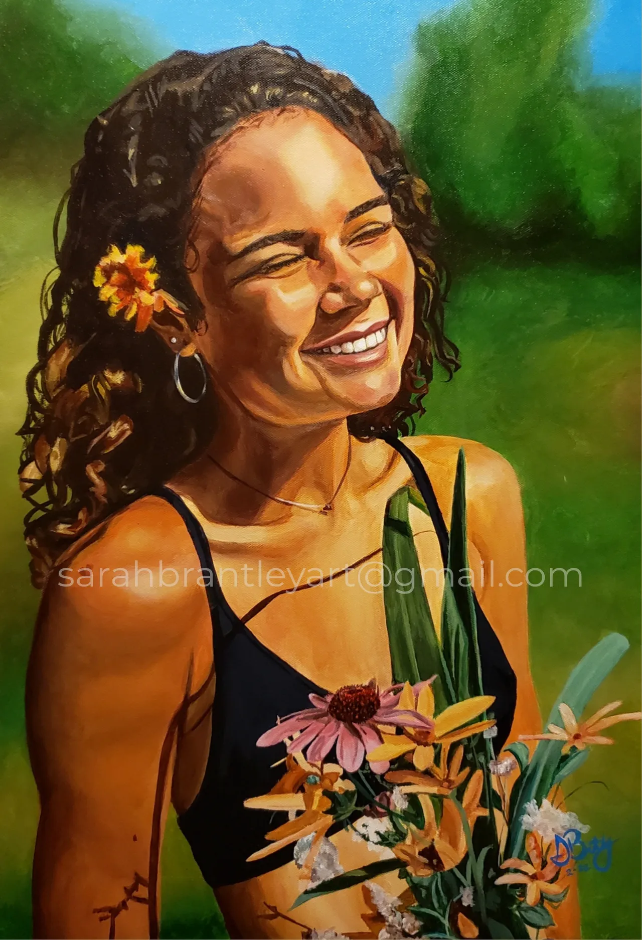 A smiling woman with curly hair, a flower in her hair, wearing a black tank top, holding flowers against a vibrant outdoor background.