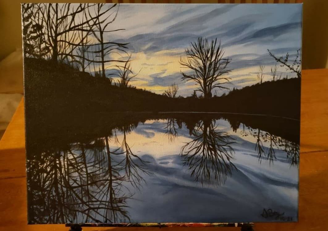 A painting of a sunset or sunrise over a lake with silhouetted trees and their reflections in the water.