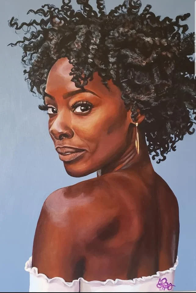 Portrait of a woman with dark, curly hair and a tan complexion, wearing an off-the-shoulder white top and a gold earring, looking over her shoulder.