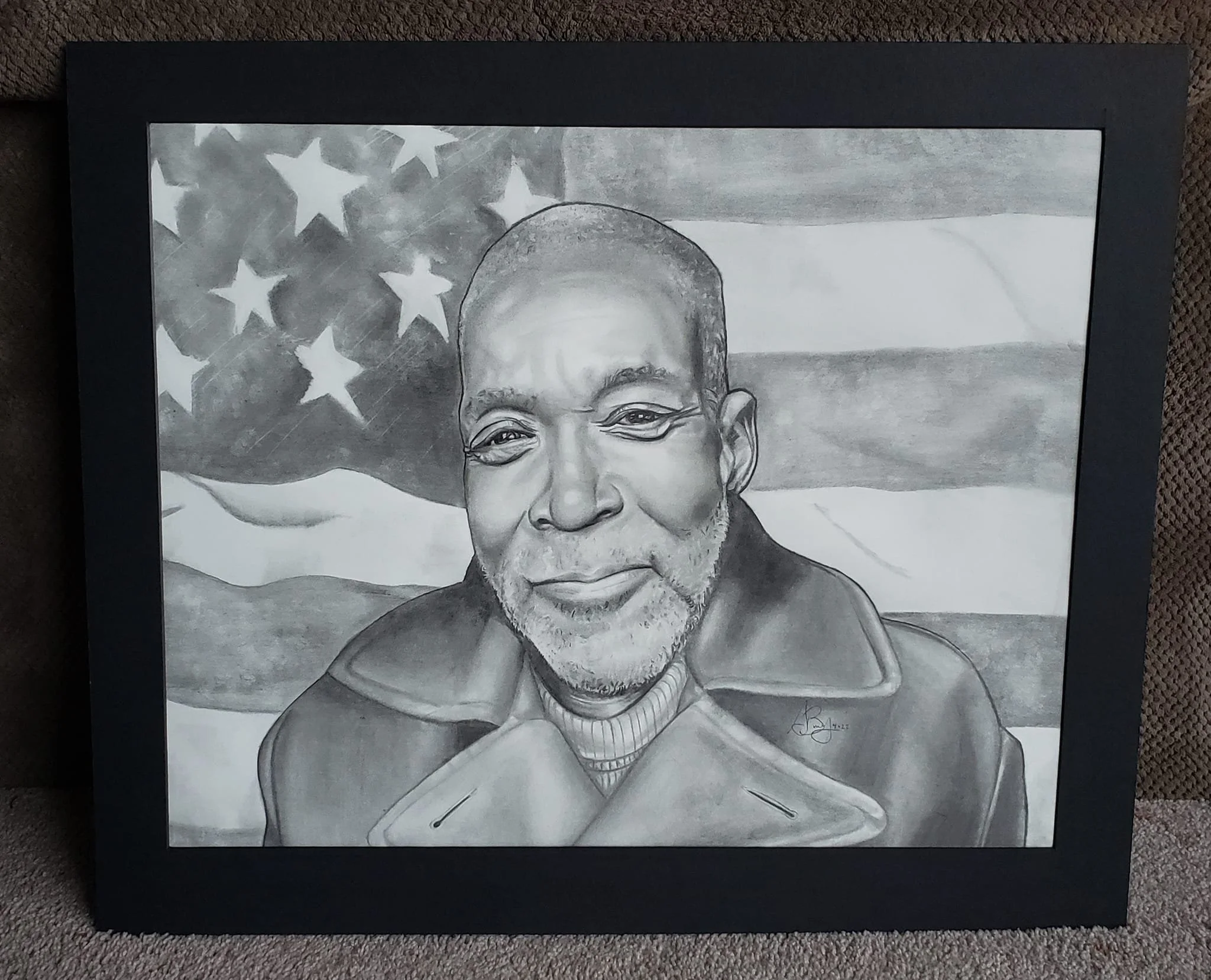 A pencil drawing of an older African American man with a beard, smiling, wearing a coat with a high collar, with an American flag in the background.