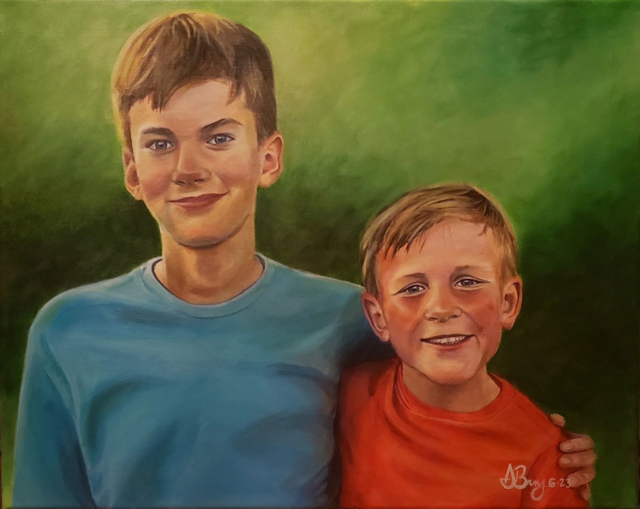 Portrait of two young boys with smiling faces, one older with short brown hair wearing a blue shirt, and one younger with short blonde hair wearing an orange shirt, against a green background.