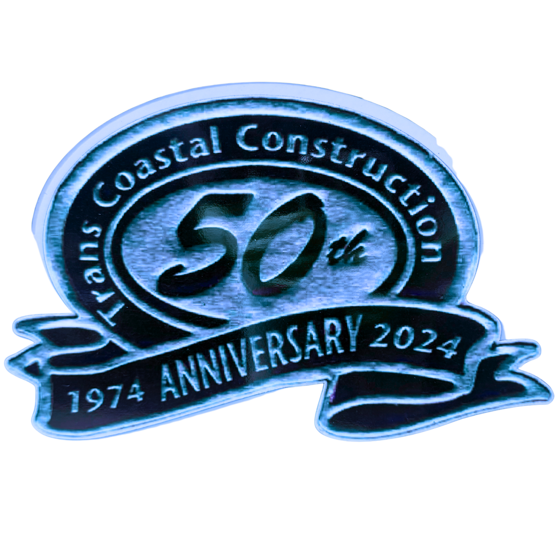 Close-up of a commemorative coin celebrating the 50th anniversary of the Coastal Construction company, with the year 1974 and the year 2024 marked on it.