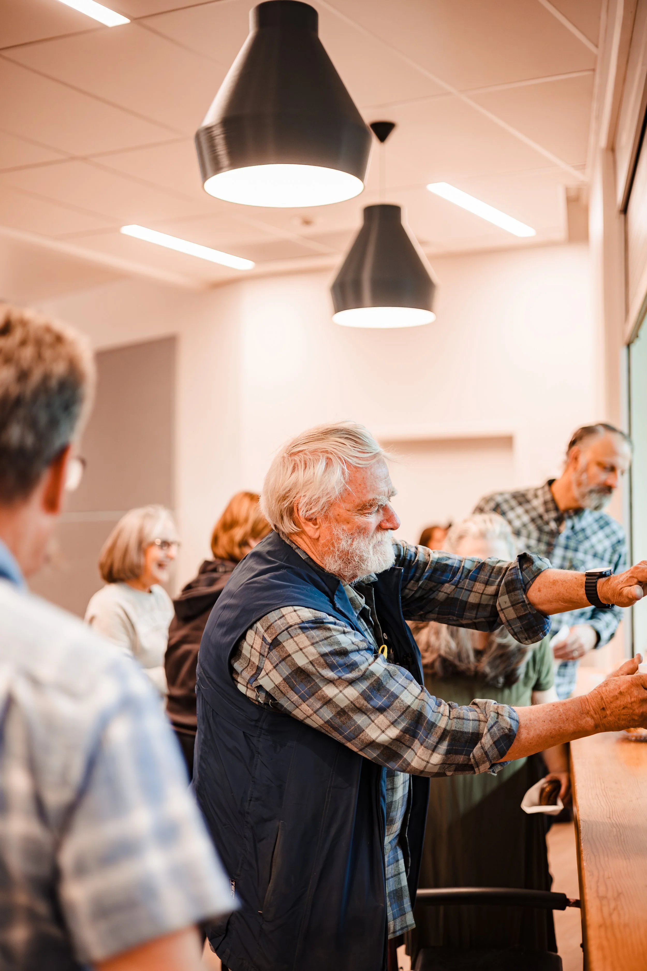 Candid corporate event photography of a speaker presenting to a group during a business workshop or seminar in a modern indoor venue.