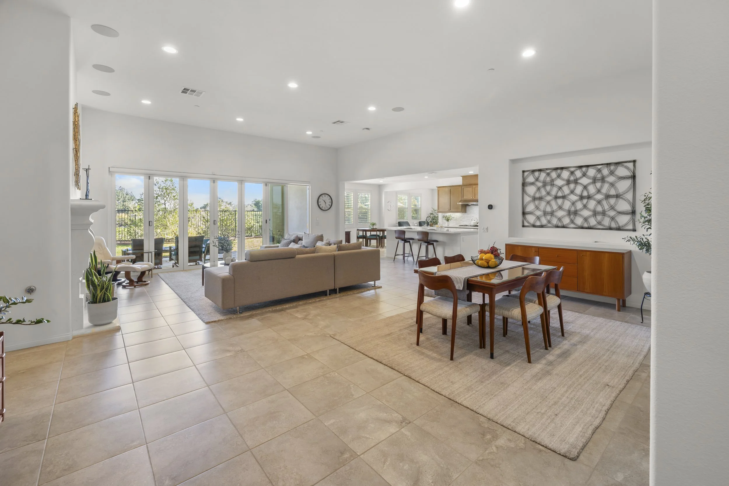 Professional interior real estate photography of an open-concept living and dining room with modern furniture, natural light, and sliding glass doors for residential property listings.