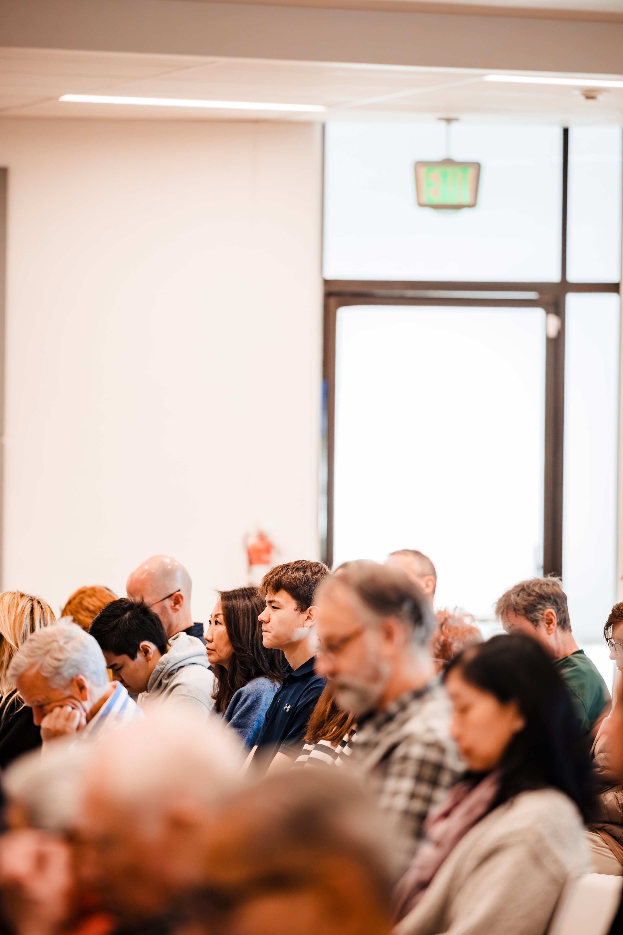 Corporate event photography of a professional audience attending a business meeting or conference in a modern indoor setting for company marketing and brand storytelling.