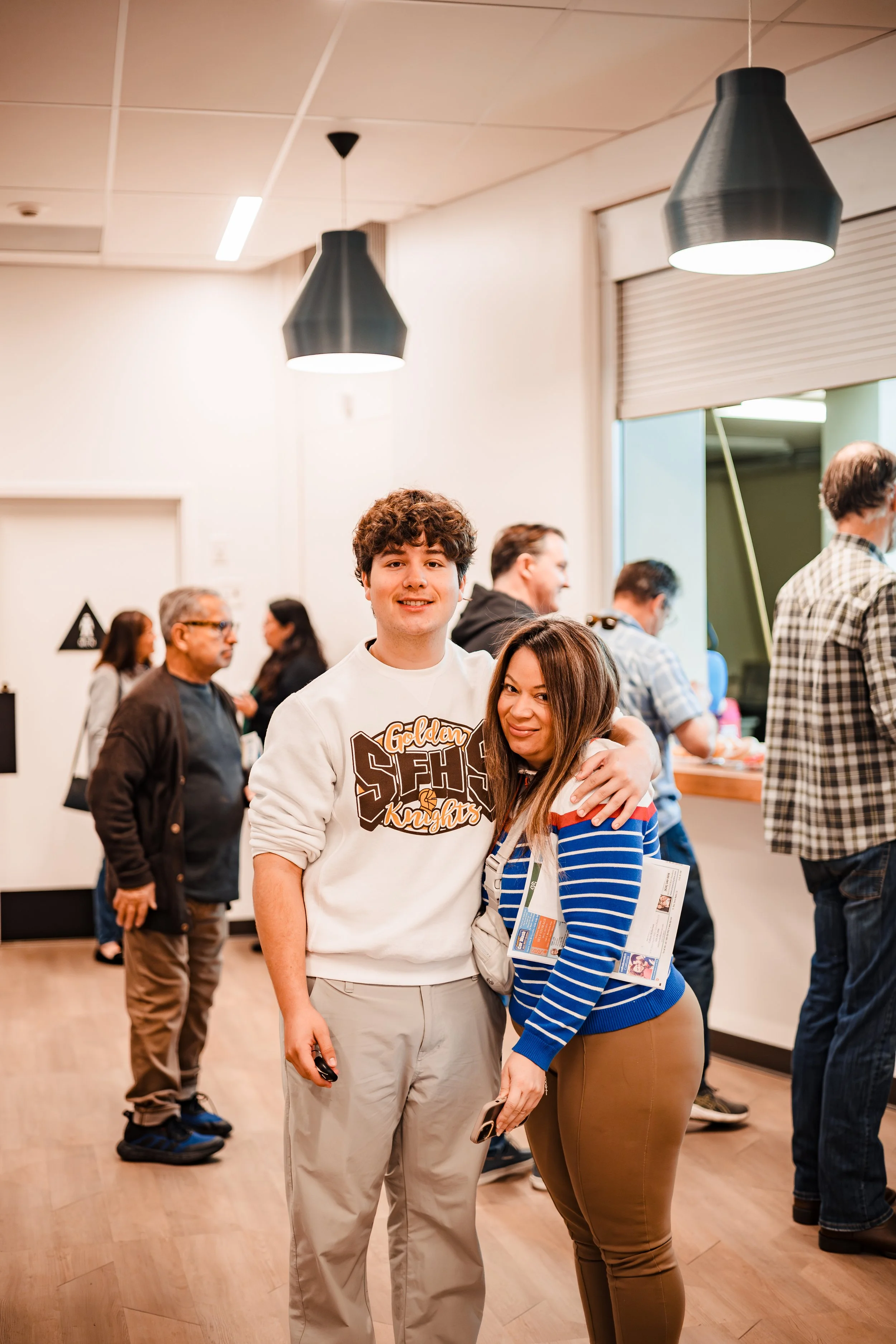 Professional corporate lifestyle photography capturing a genuine interaction and embrace between attendees at a networking event or company gathering.