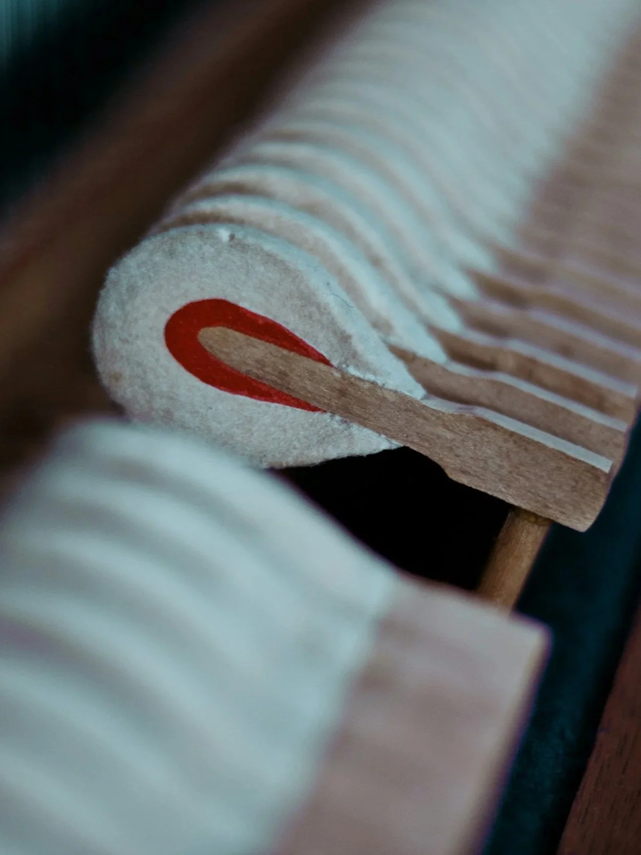 Close-up of dusty piano hammers inside of an upright piano.