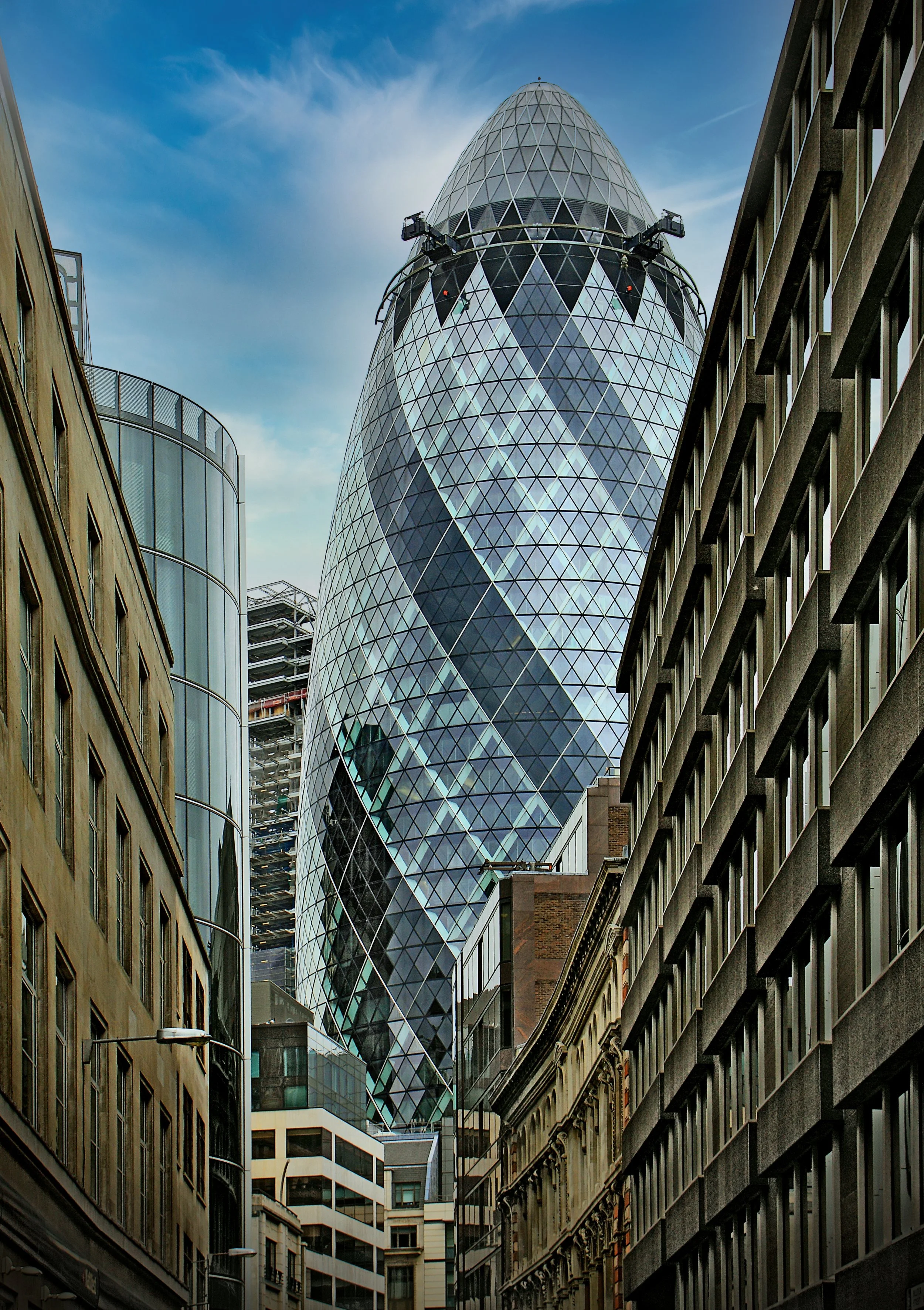 Downtown London with the modern Gherkin building towering above older surrounding buildings.
