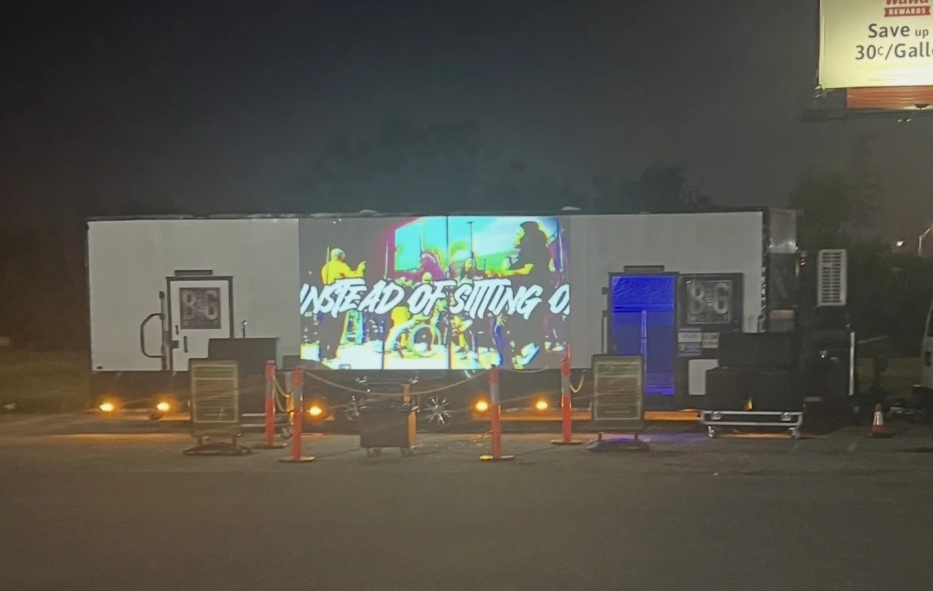 A mobile billboard at night displaying a colorful animated advertisement