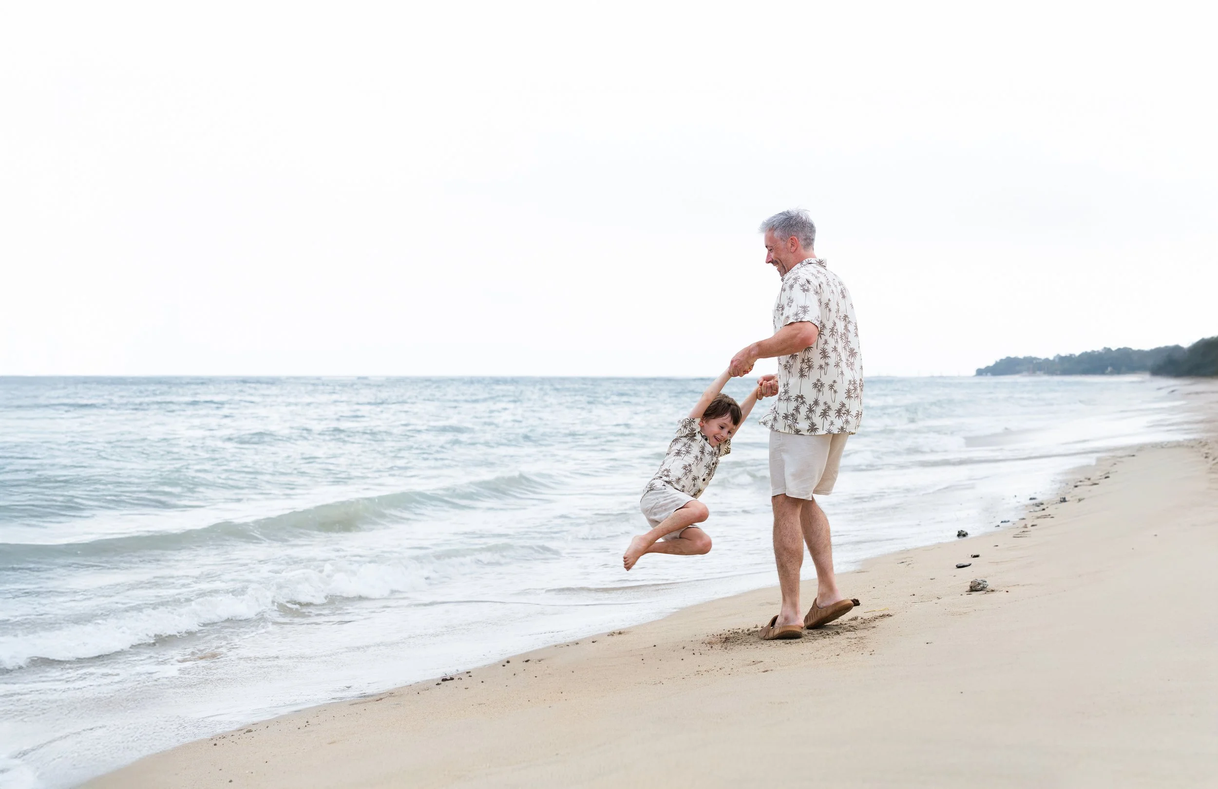 hoogbegaafd kind speelt samen met vader op het strand
