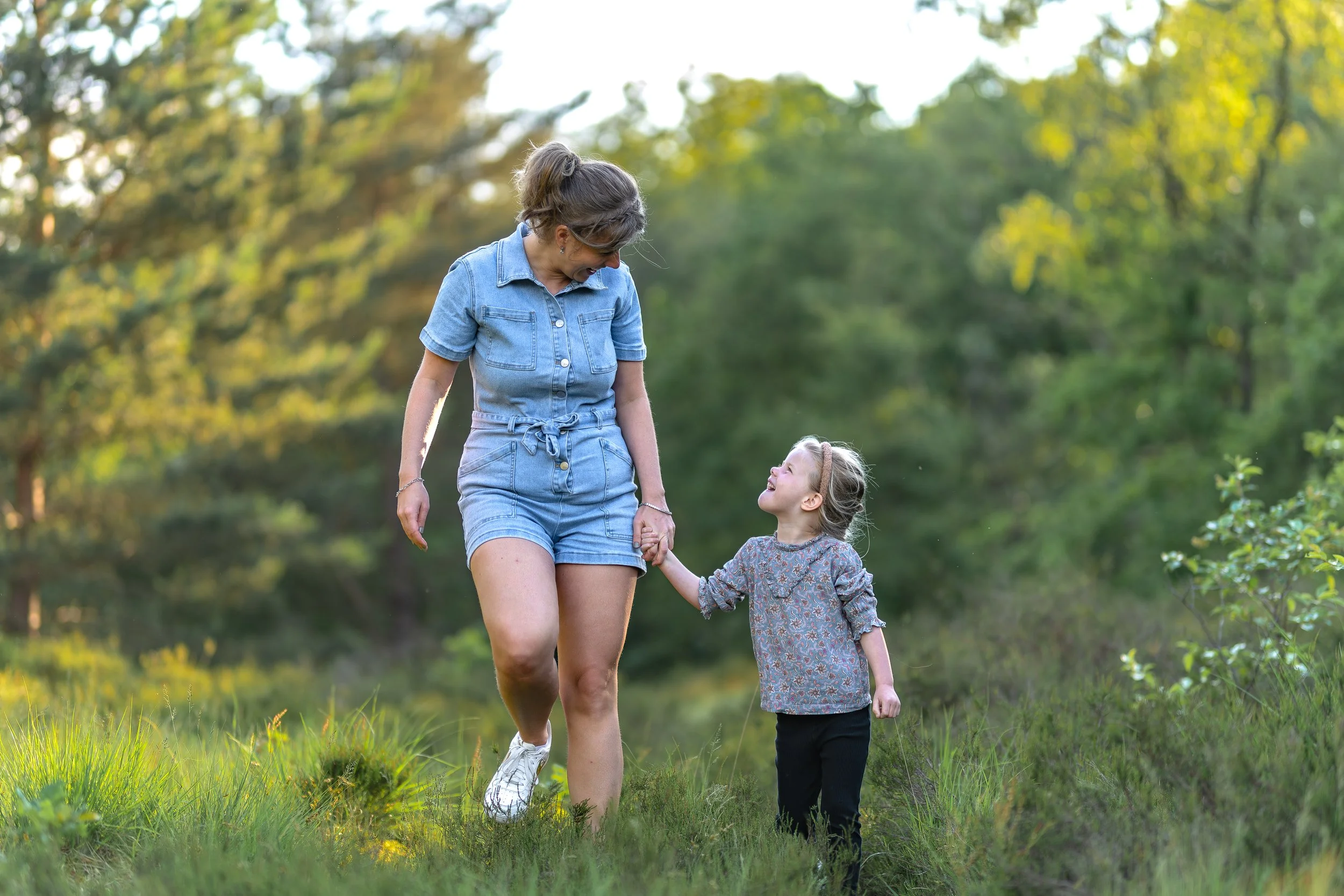 Moeder en Dochters hand in hand tijdens boswandeling spontane fotoshoot