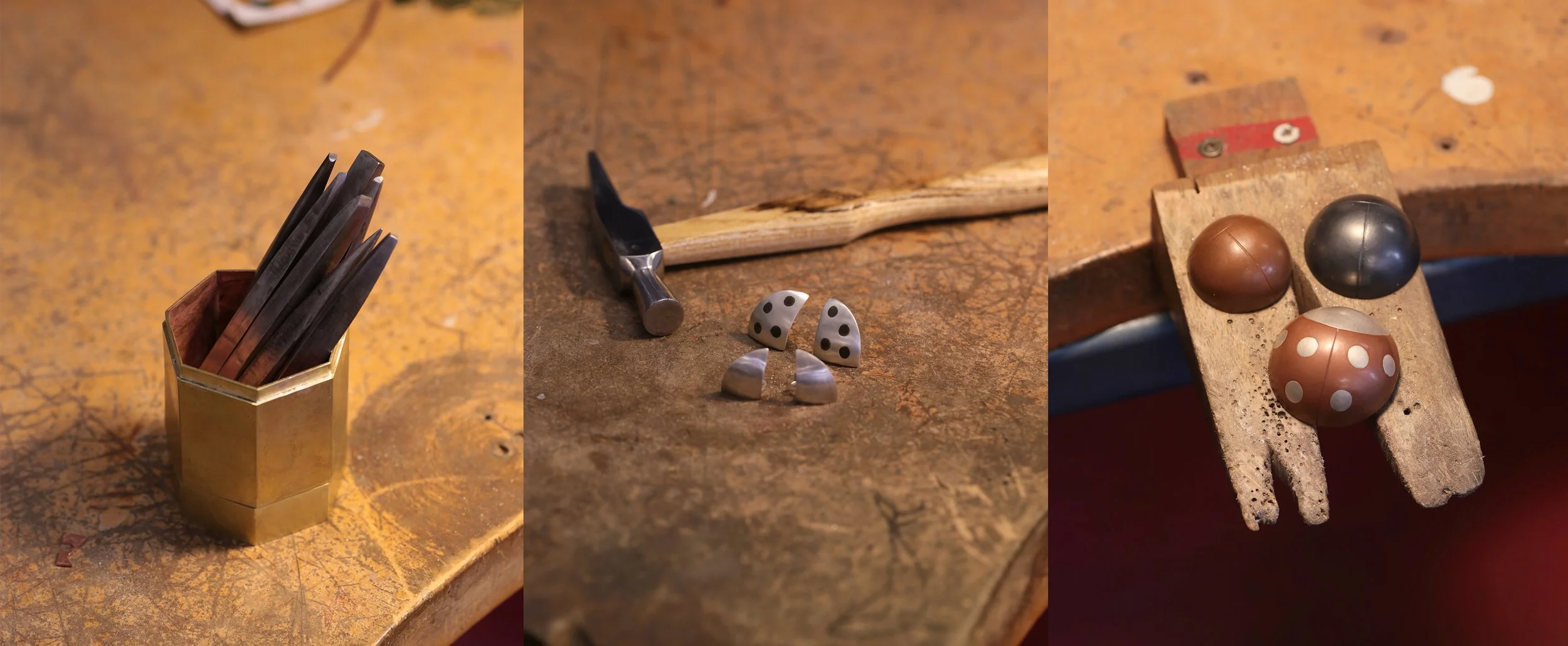 Tools and materials used in metalworking art, including a container of metalworking punches, a small hammer, and some jewellery.