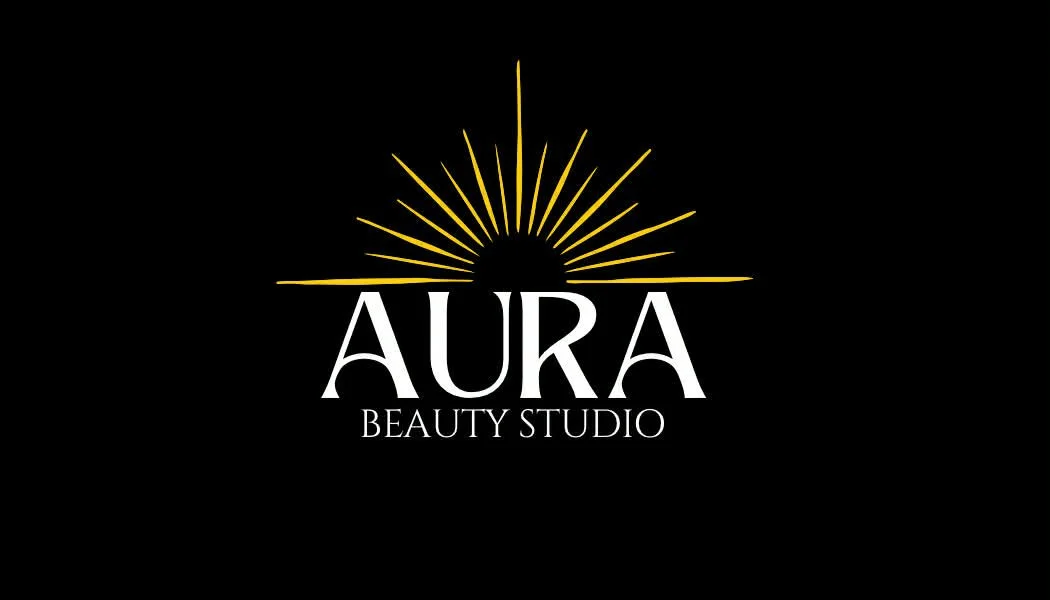 Logo for Aura Beauty Studio featuring a stylized sun with radiating rays above the name.