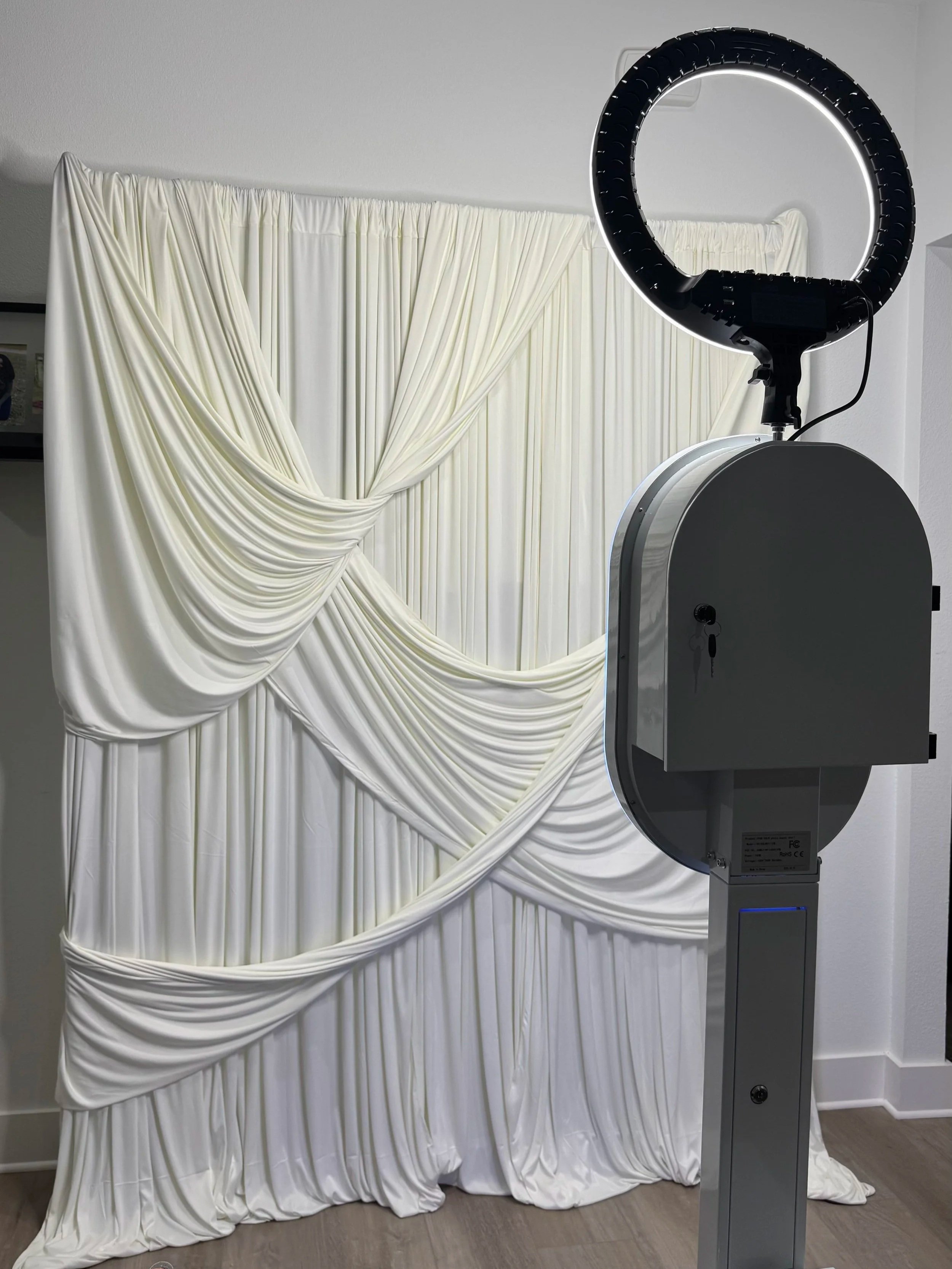 A backdrop made of white draped fabric with gathered and pleated details, set up for a photo or event.