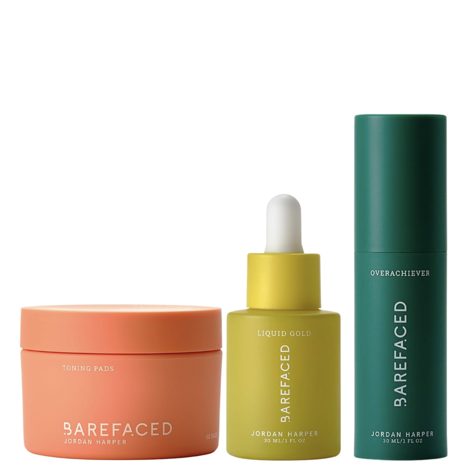 Set of three skincare products: a peach-colored jar labeled 'Toning Pads,' a yellow bottle with a dropper labeled 'Liquid Gold,' and a teal tube labeled 'Overachiever' by Barefaced Jordan Harper.
