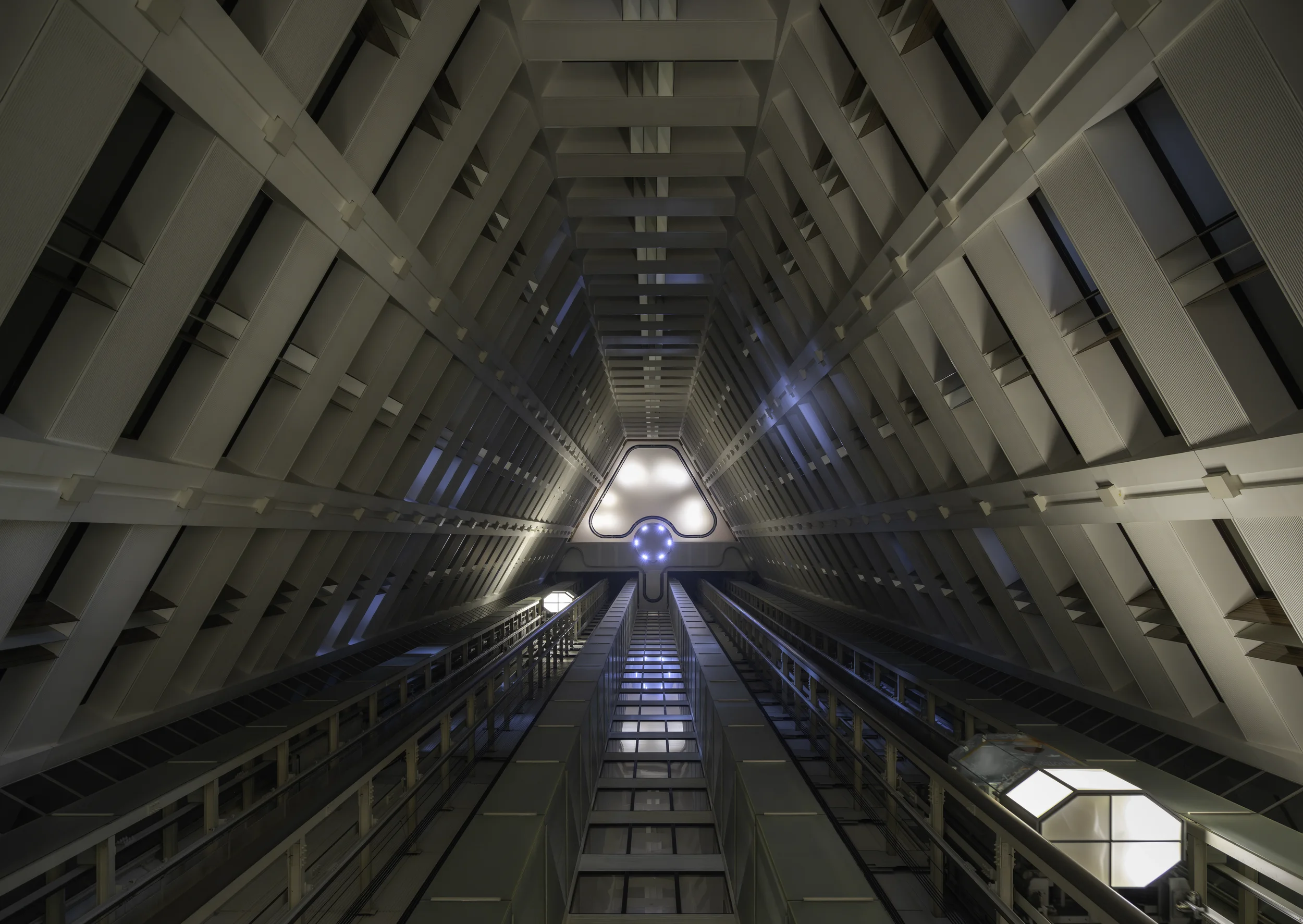 Symmetrical hotel elevator photographed from below, emphasizing geometric lines and contemporary interior architecture in Japan.