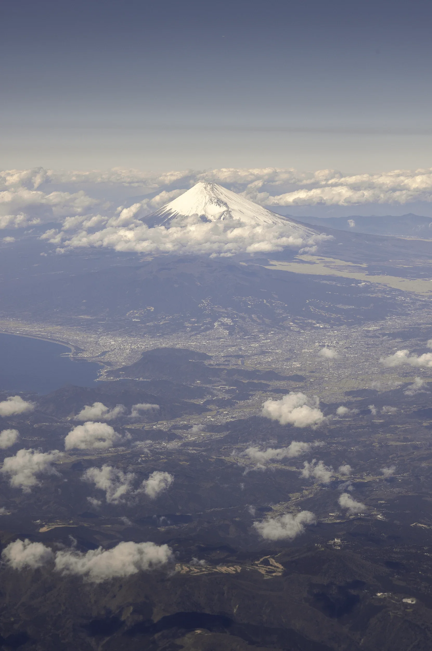 Seen from an aircraft, Mount Fuji dominates the landscape from above the clouds. Its near-perfect volcanic cone becomes even more striking when viewed from a perspective rarely experienced from the ground.