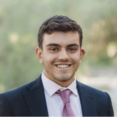 Portrait of a smiling young man in a suit outdoors