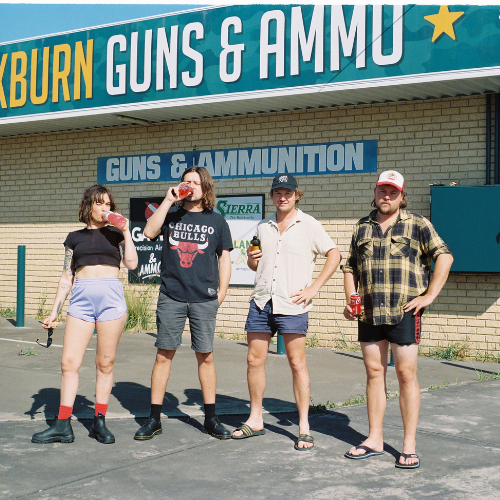 Four young people standing outside a gun and ammunition store, drinking from bottles and cans, with a store sign reading "Guns & Ammunition" in the background.