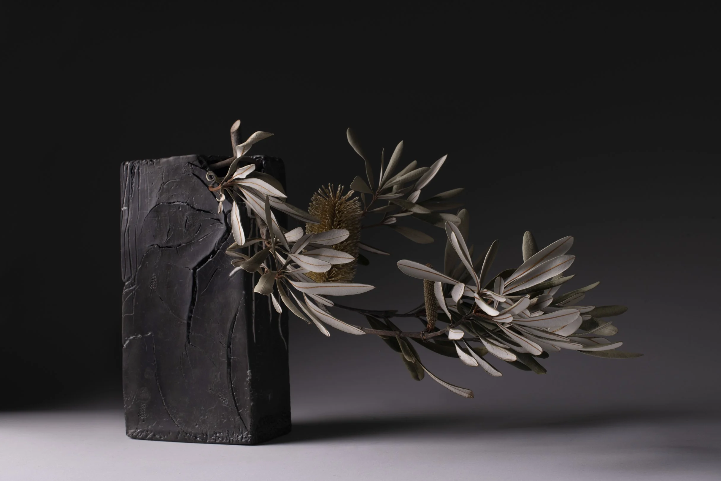 a handmade ceramic ikebana vessel with banksia flower arrangement