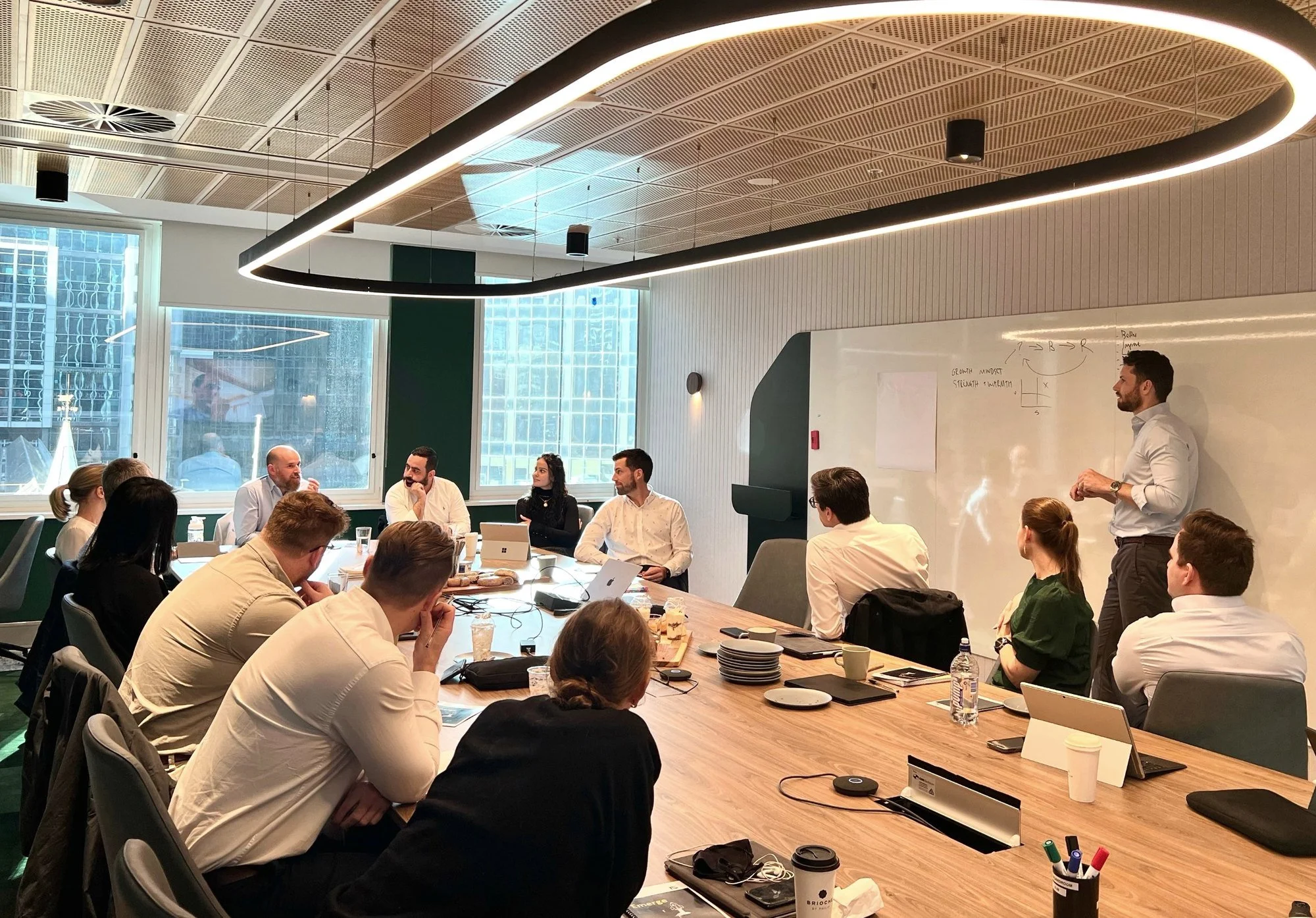 Linton Chalmers running a session with a large leadership group around a boardroom table
