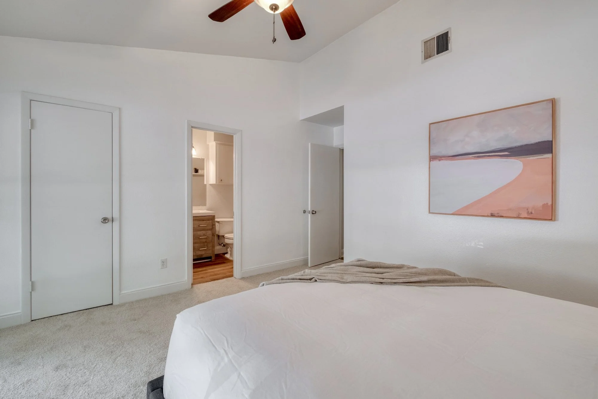 Bedroom with ensuite bathroom and neutral finishes
