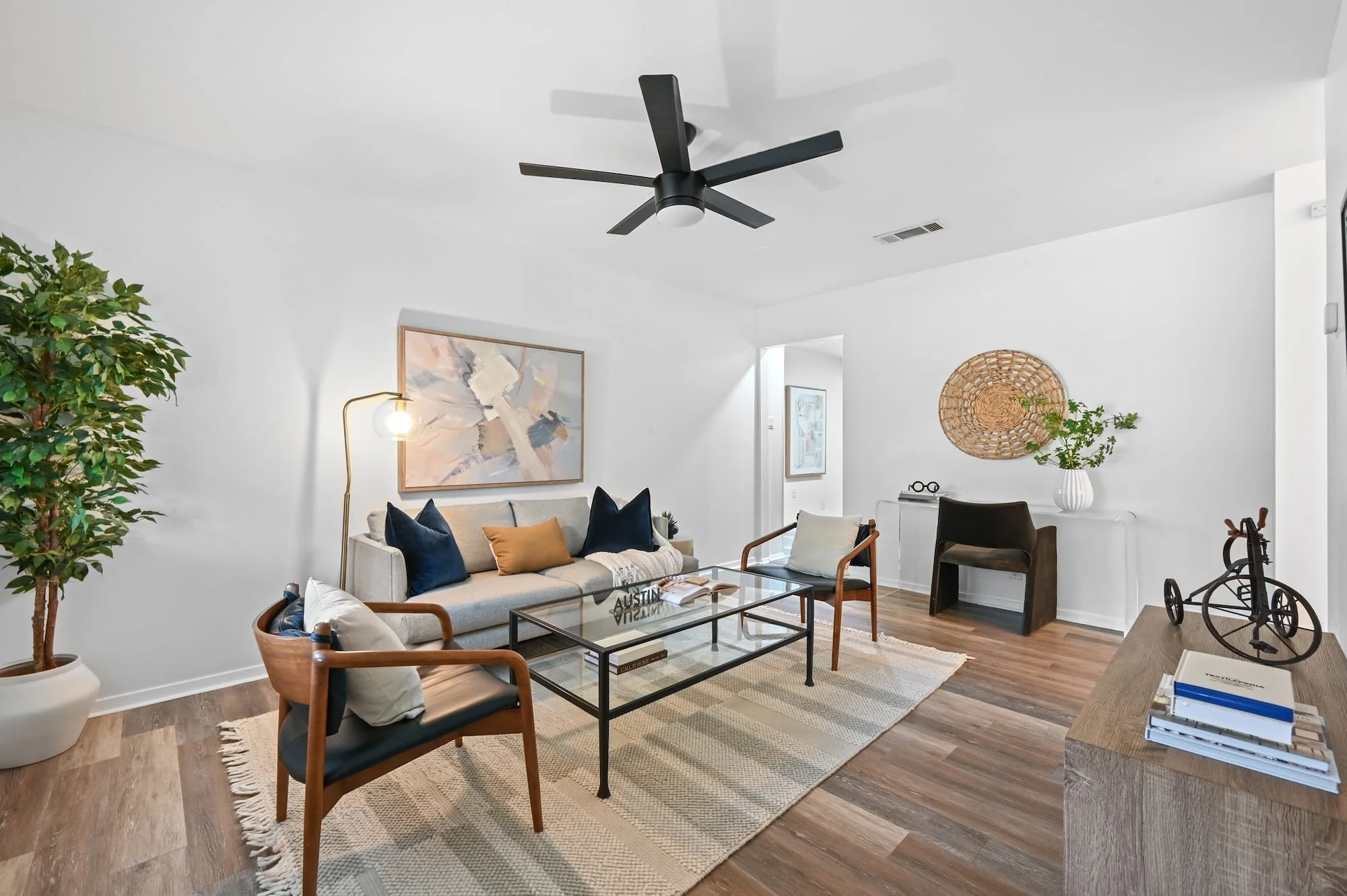 A tall potted plant and woven wall basket add texture to this open living room.