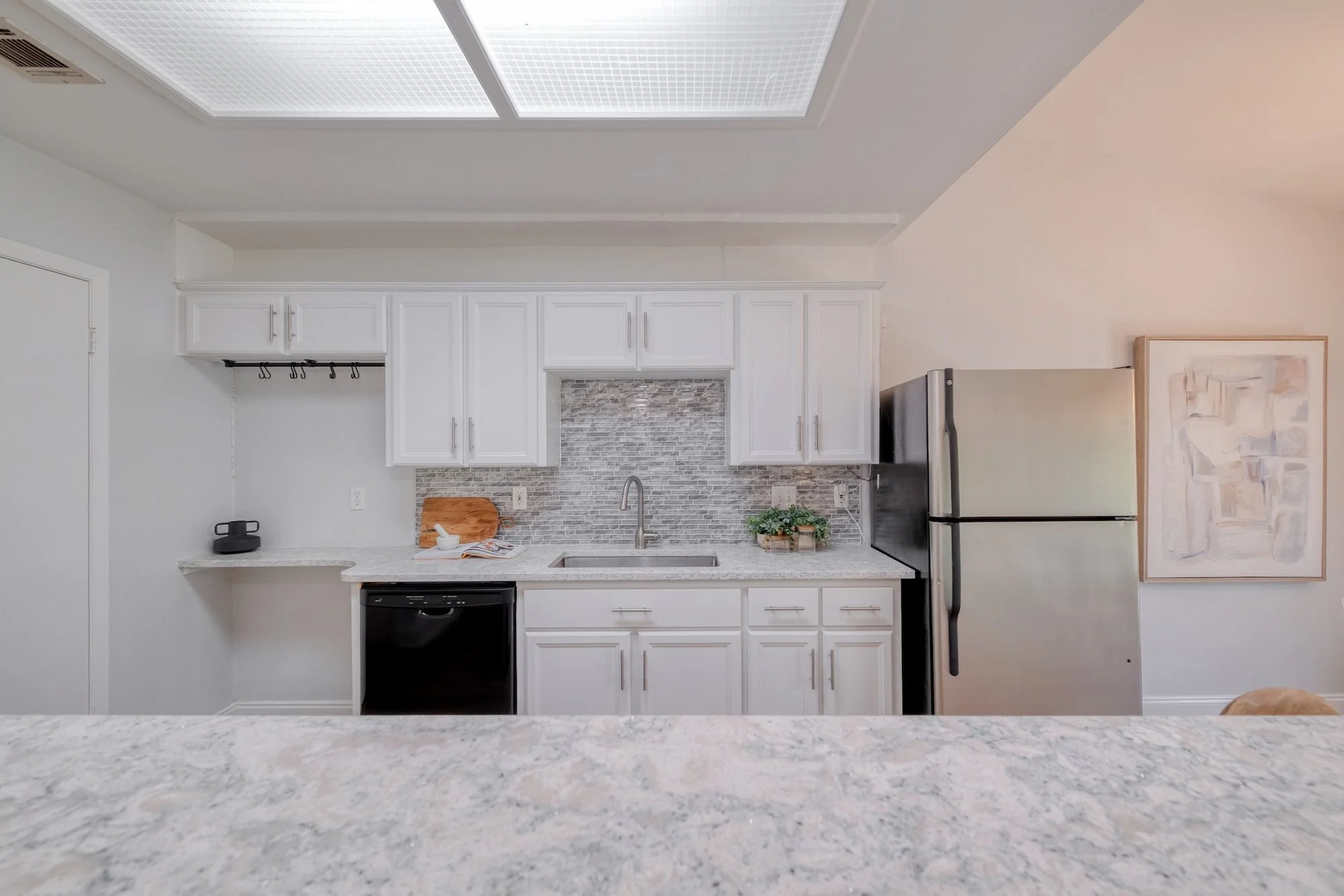 Bright kitchen with white cabinetry and modern finishes.