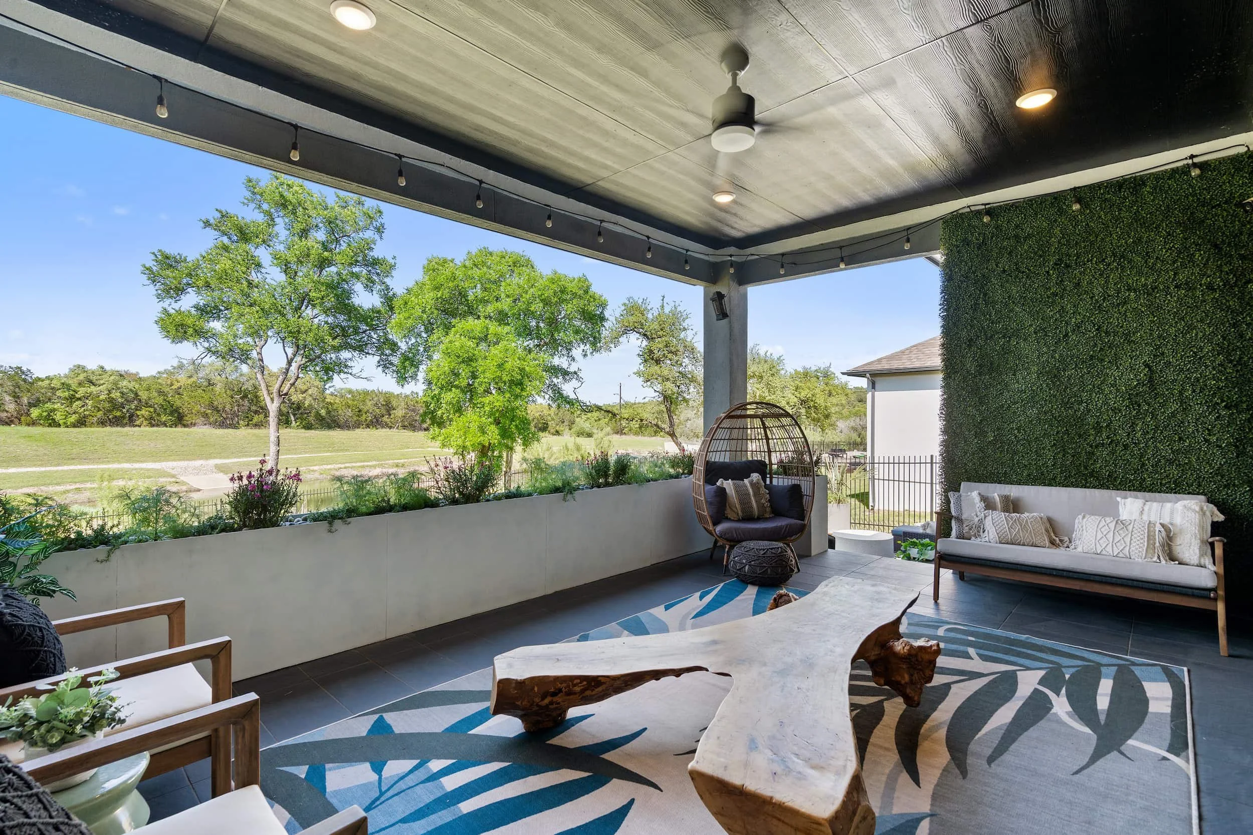 Luxurious outdoor lounge in Austin featuring contemporary staged furniture, integrated planters, and biophilic accents.