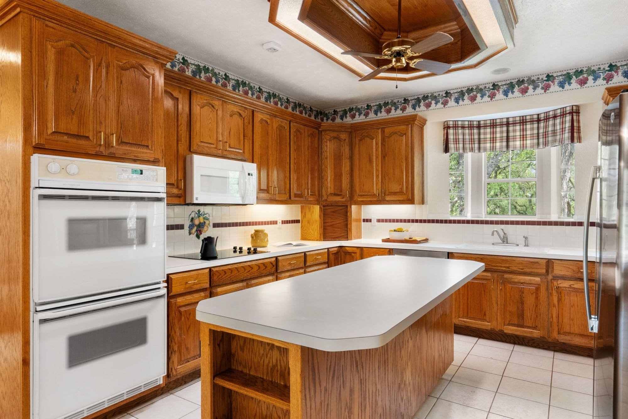 Kitchen with wood cabinetry, a center island, and windows overlooking the Georgetown property.