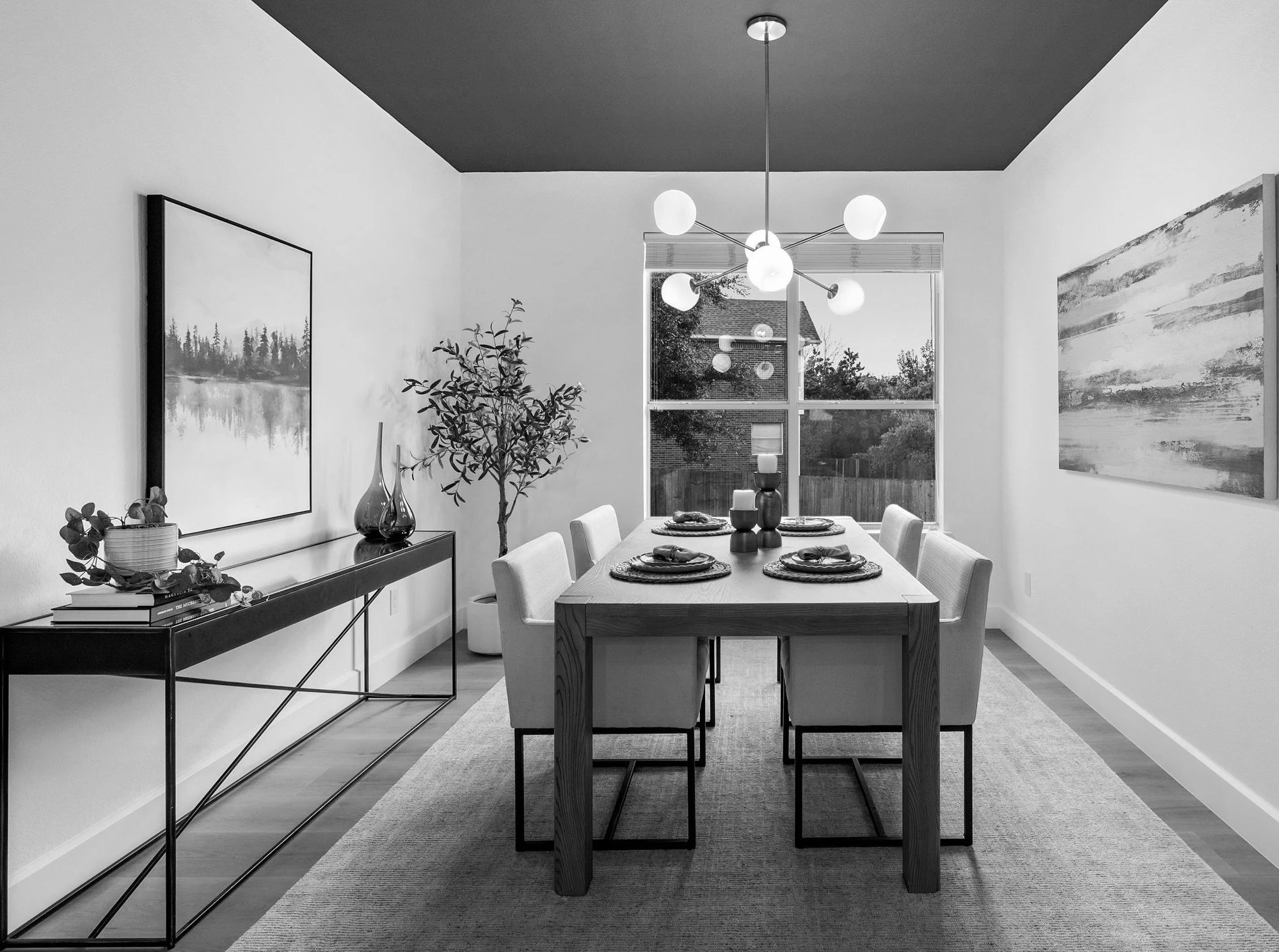 Staged dining room with modern chandelier, dark ceiling, and large windows in Austin, Texas