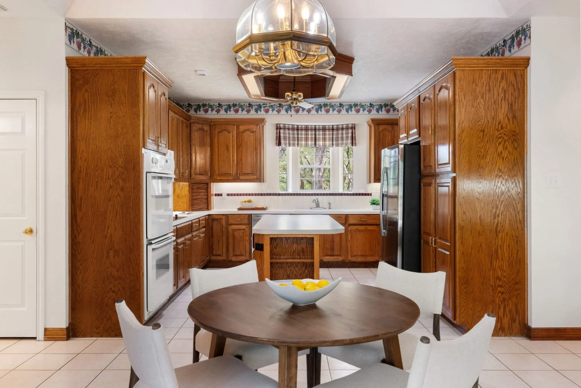 Kitchen with wood cabinetry, a center island, and an adjacent breakfast area.