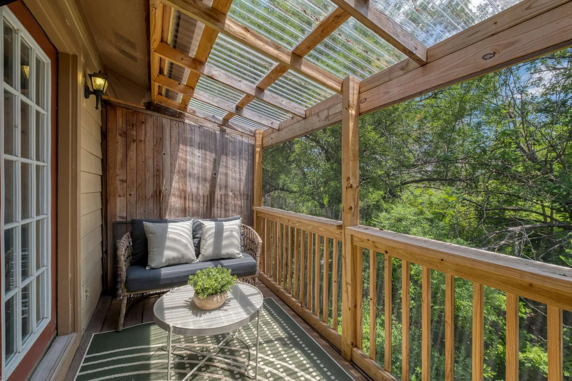 Covered balcony with seating and private tree views in Central Austin