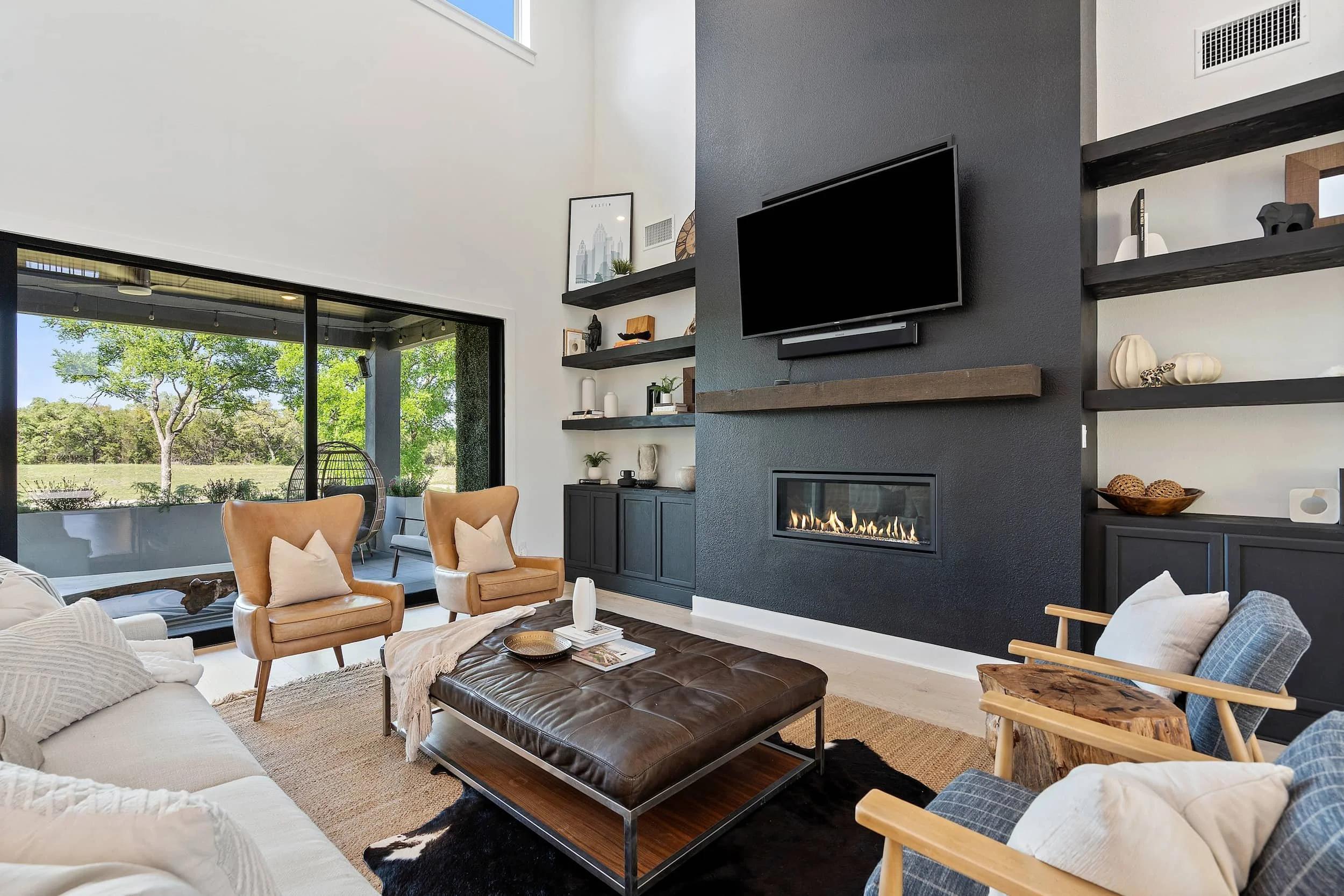 Contemporary living space with modern fireplace, neutral seating, patio view.