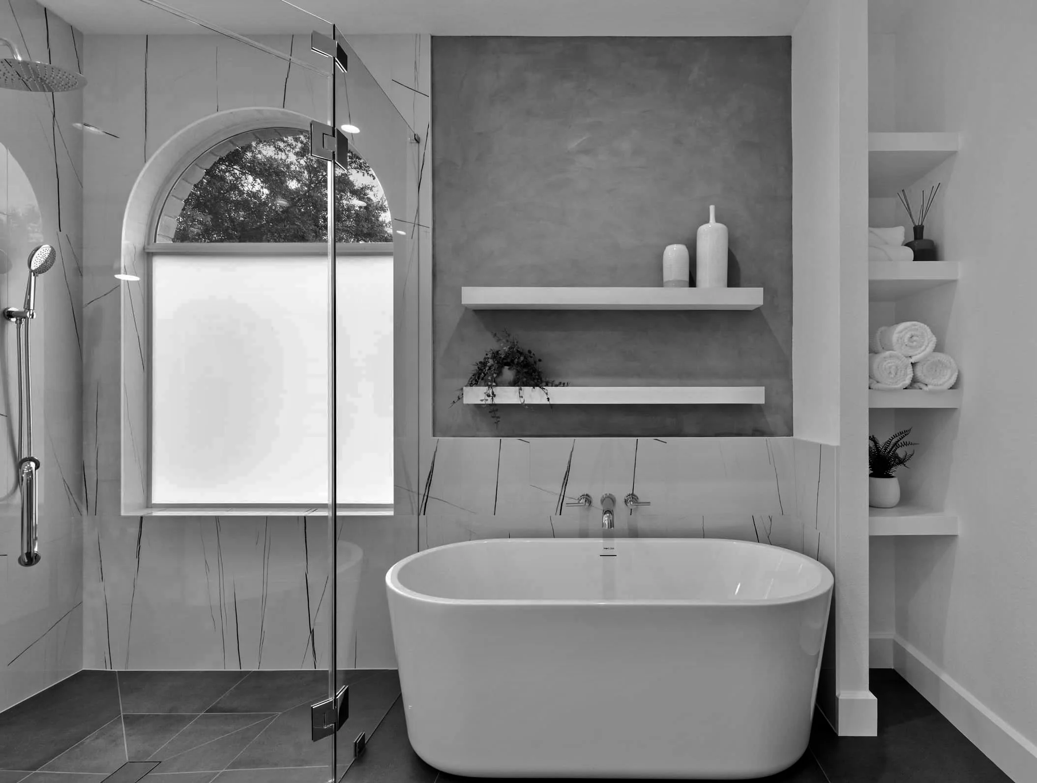 Staged bathroom with freestanding soaking tub and built-in shelving