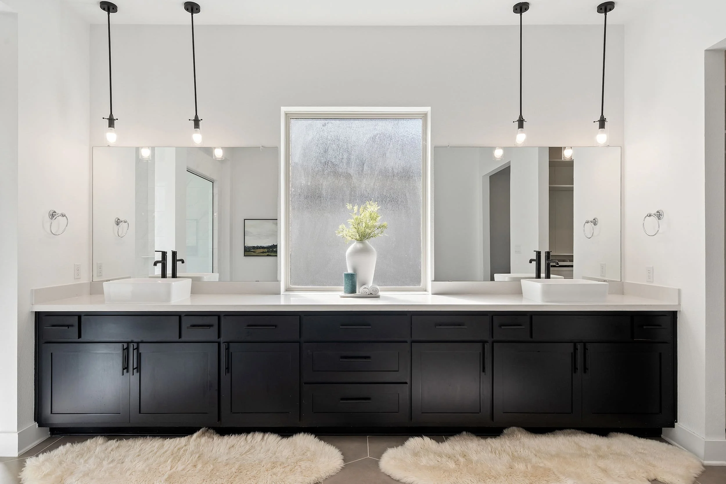 Austin bathroom with double vanity, black cabinets, vessel sinks, quartz countertop, modern lighting.