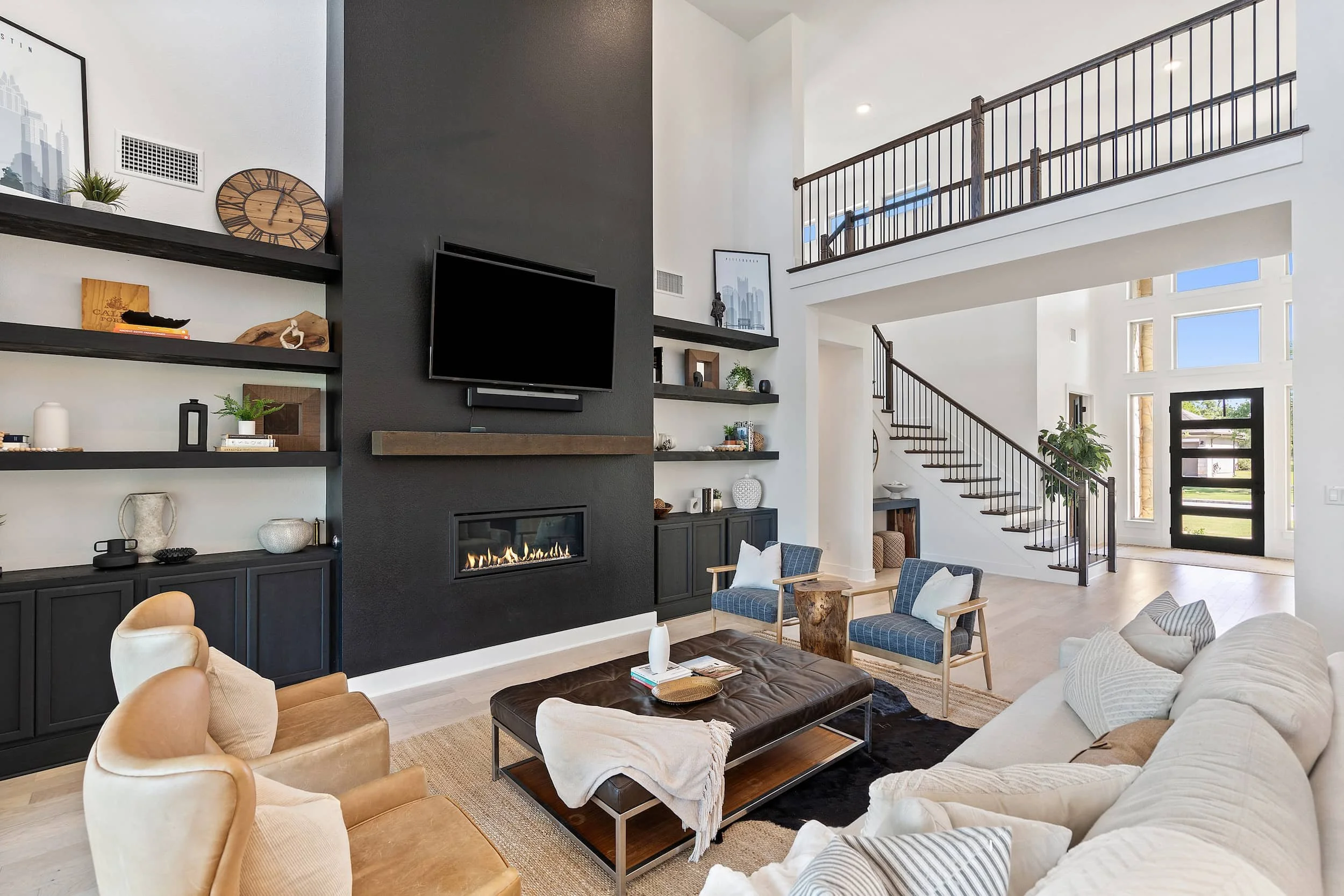 Modern Austin living space with high ceilings, statement fireplace wall, built-in shelves, soft textiles, bright natural light.