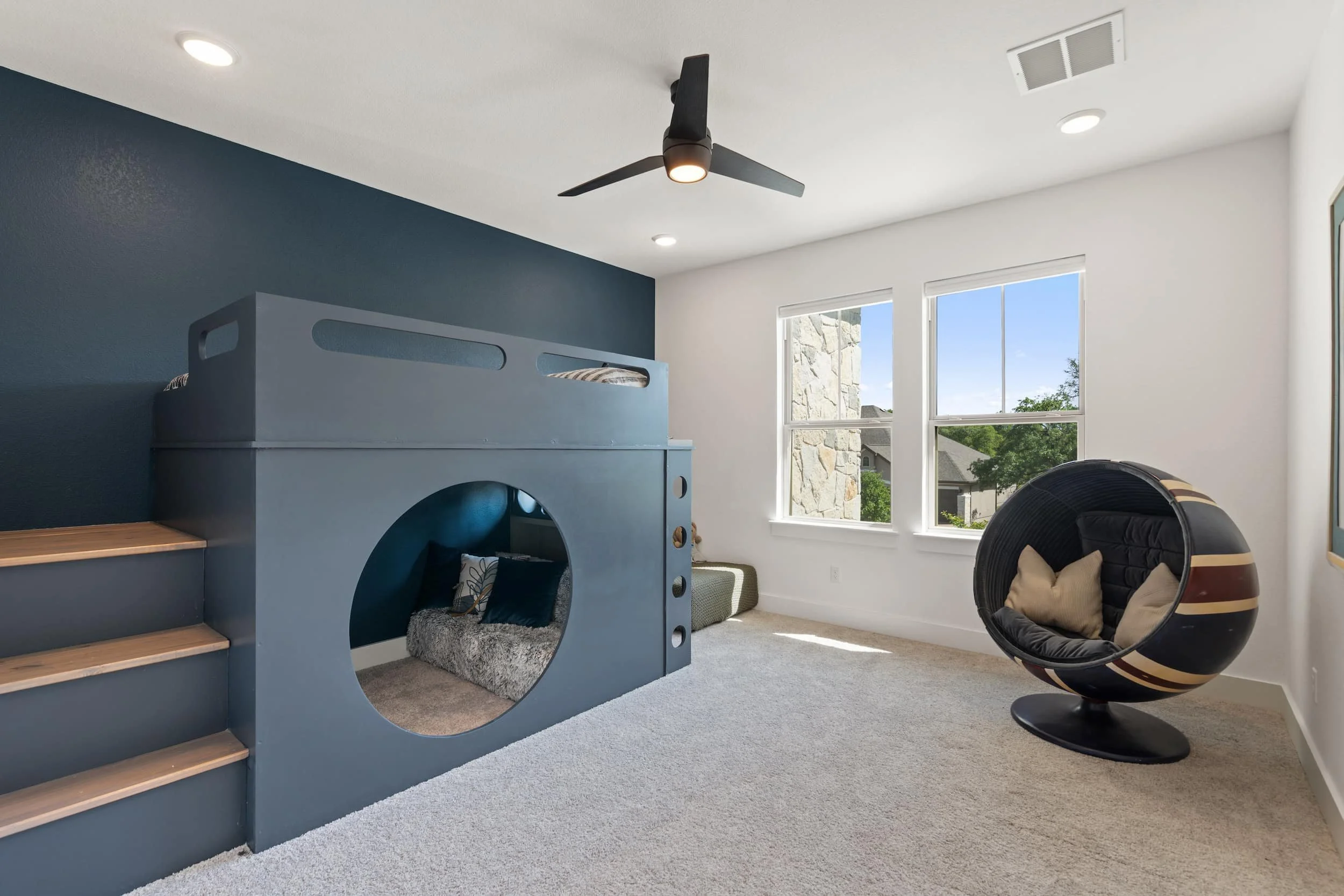 Kids bedroom in Austin with modern bunk bed, reading nook, soft carpet, accent wall, playful design.