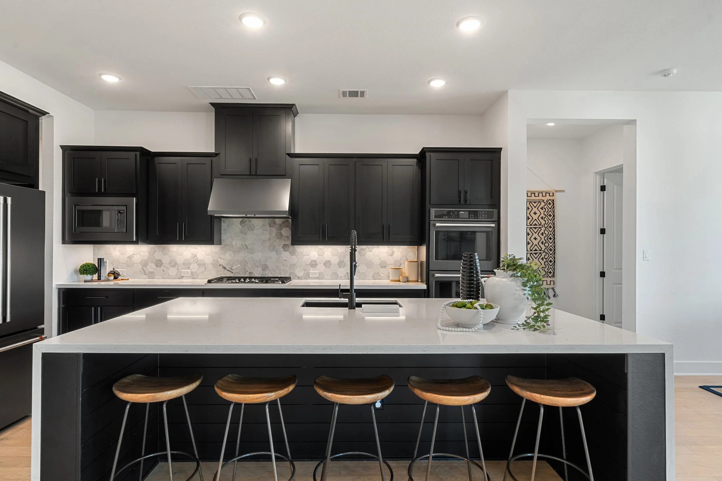 Staged property in Austin featuring contemporary kitchen with dark cabinetry, waterfall island and minimalist design.