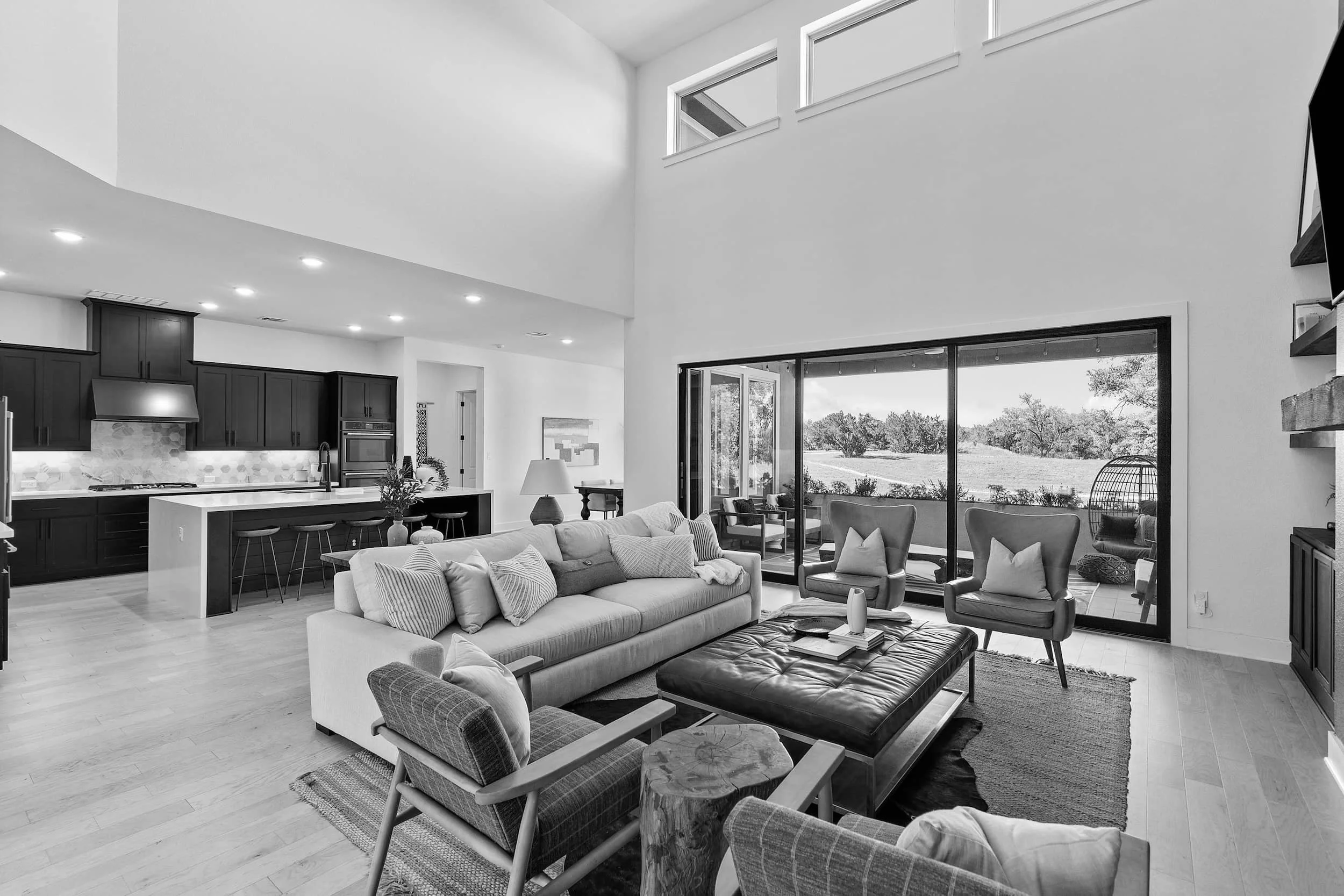 Staged open-concept living room with sofa and patio view