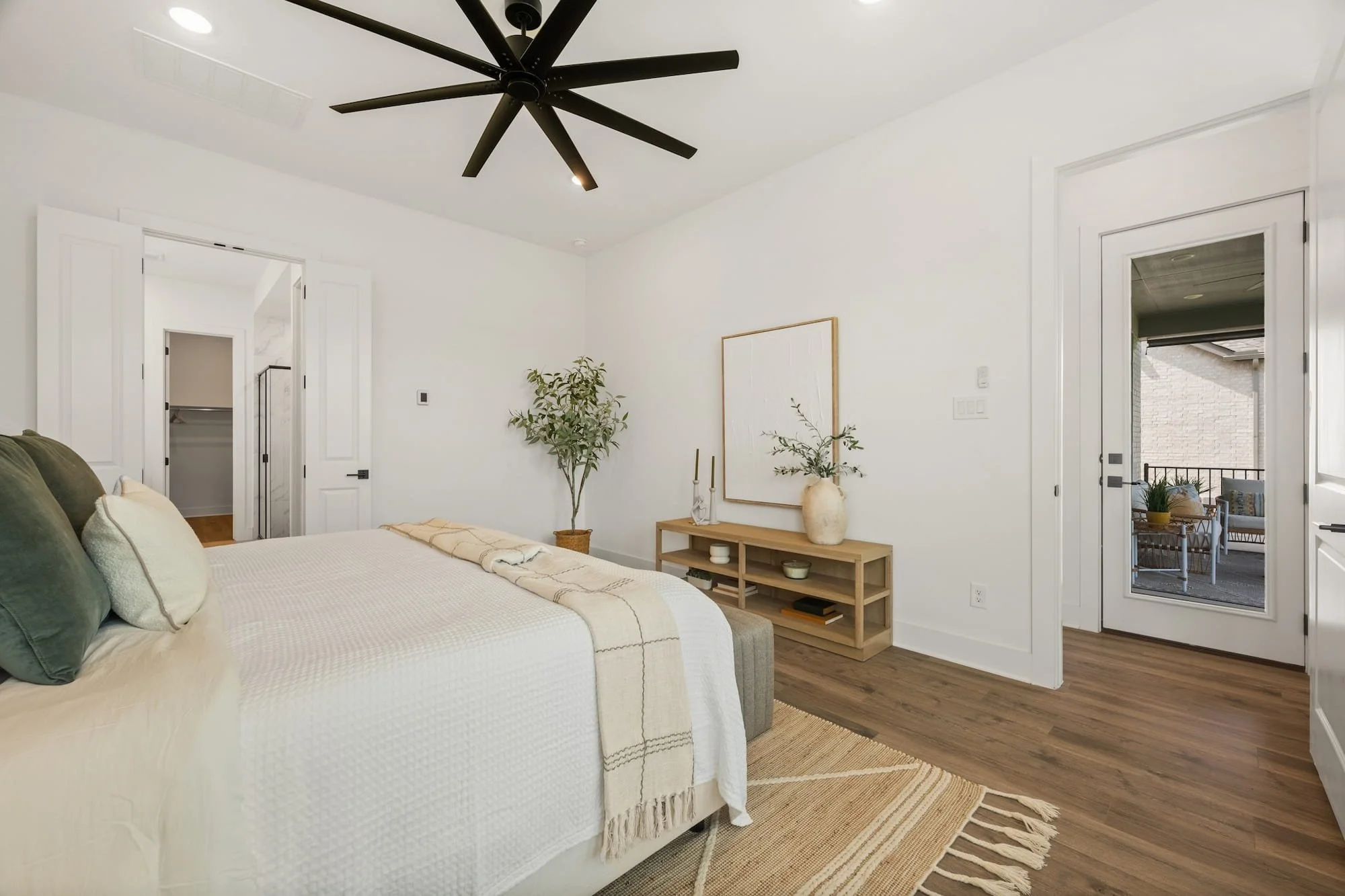 Primary suite with walk-in closet, private bath access, and covered patio entry