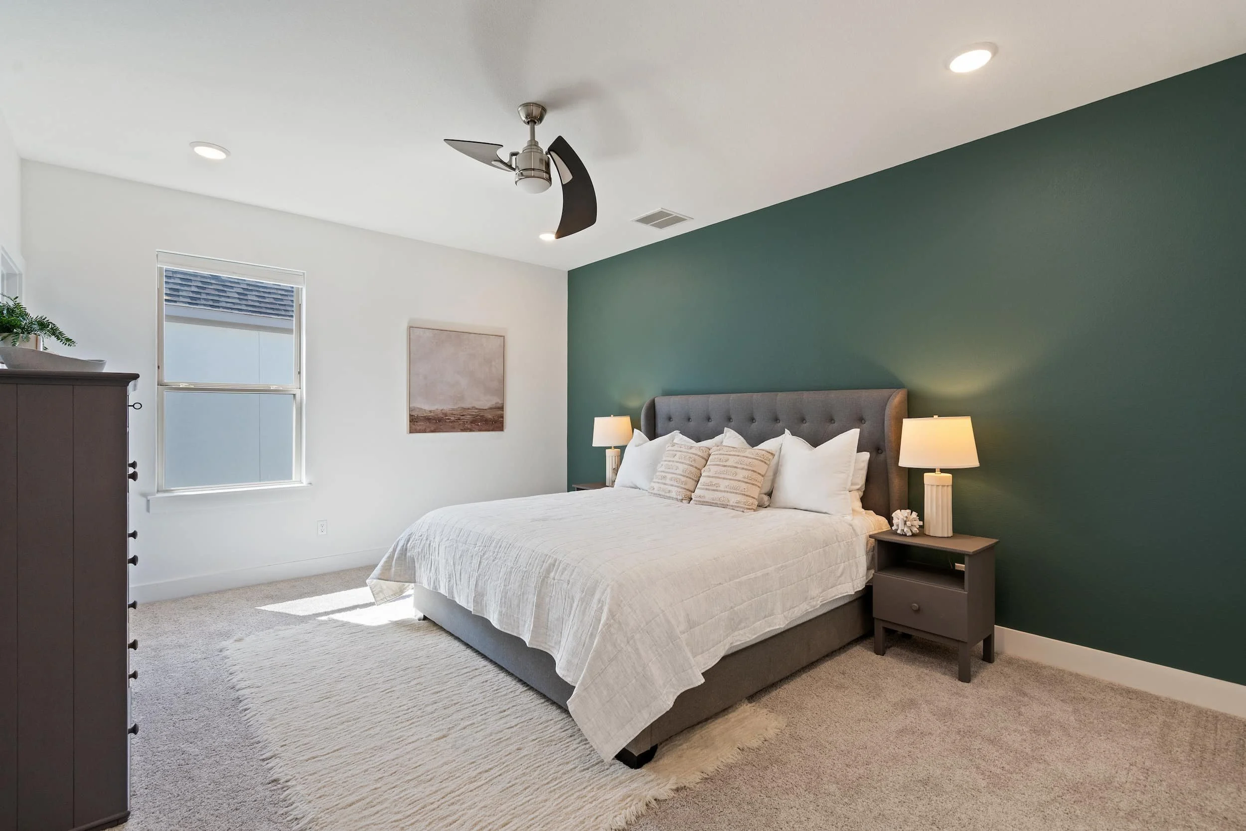 Contemporary bedroom in Austin with tufted headboard, nightstands, accent wall, soft textures, clean layout.